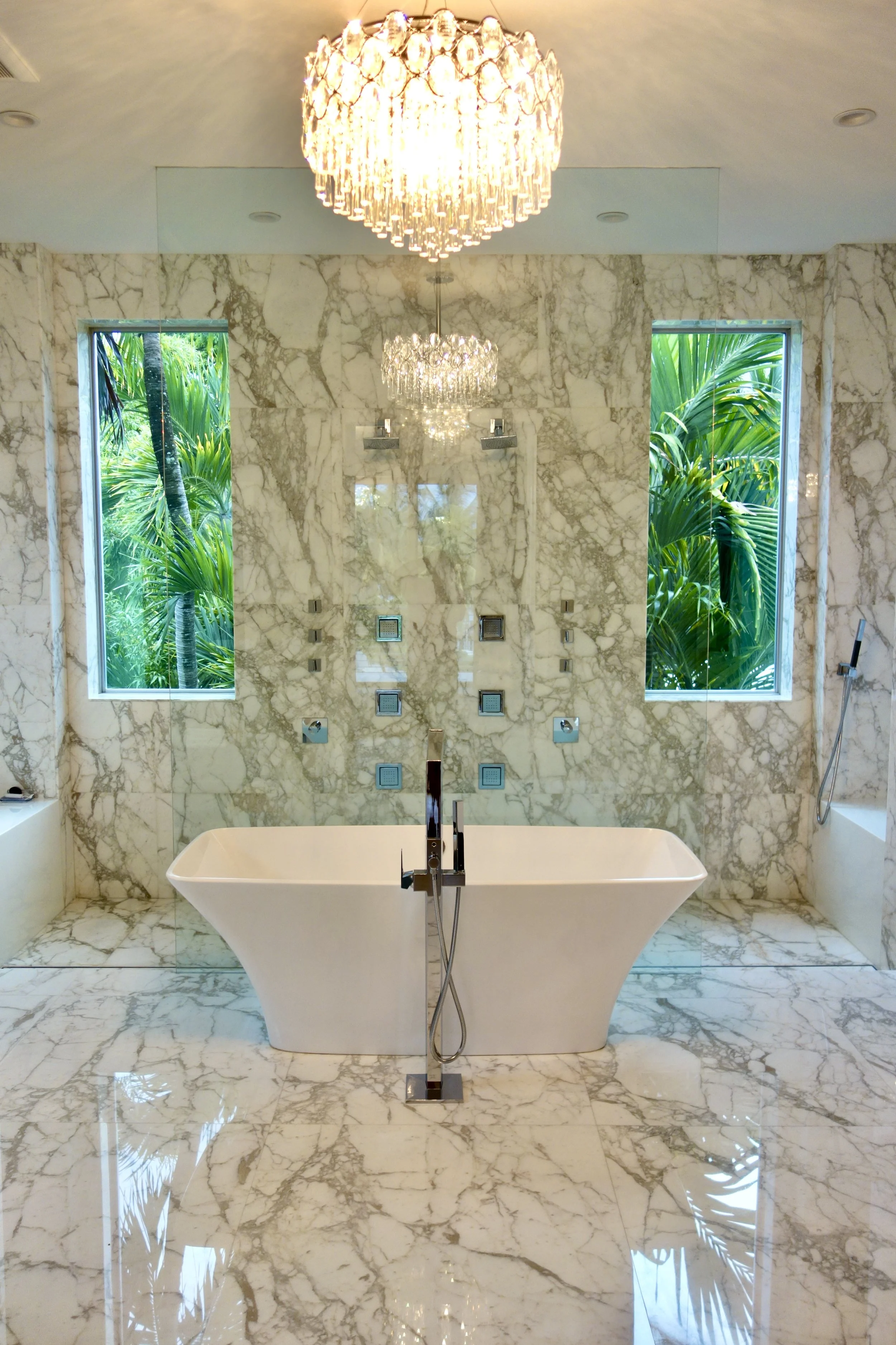 luxury marble bath room with open shower and tub with chandelier on Las Olas