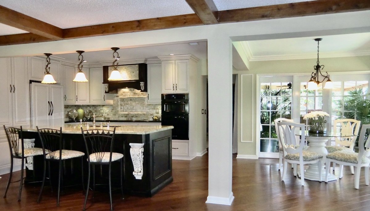 transitional kitchen remodel with cream custom cabernets and black island with traditional corbel