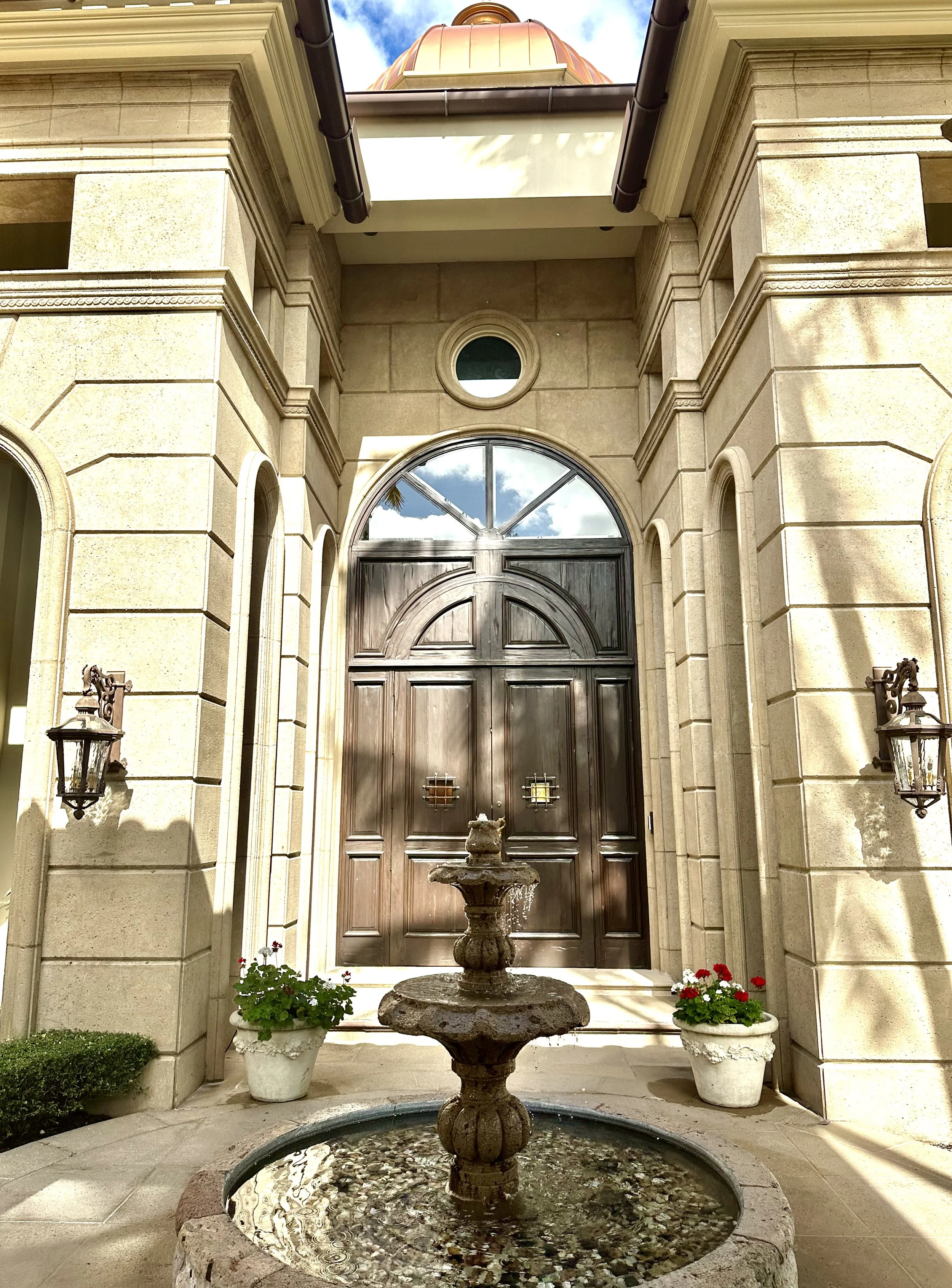 Mediterranean entrance with water fountain and arched door