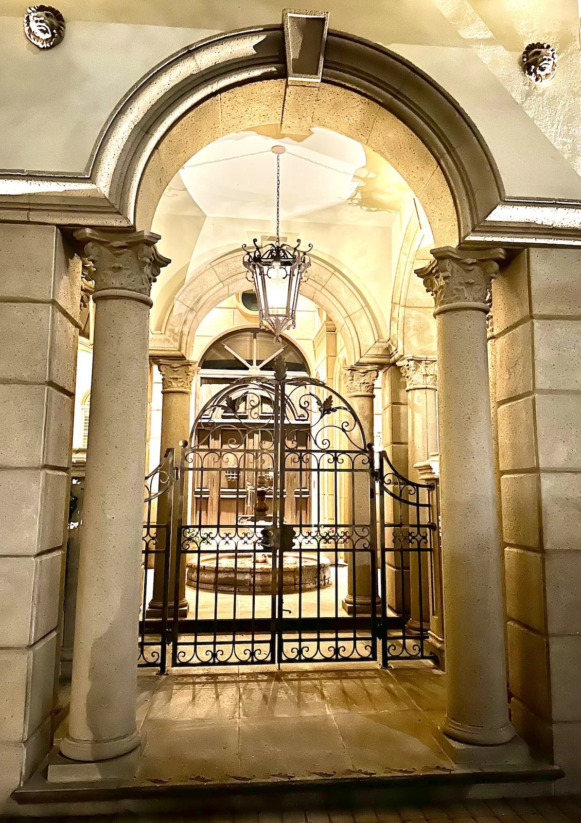 Mediterranean Revival entrance with columns and wrought iron gates