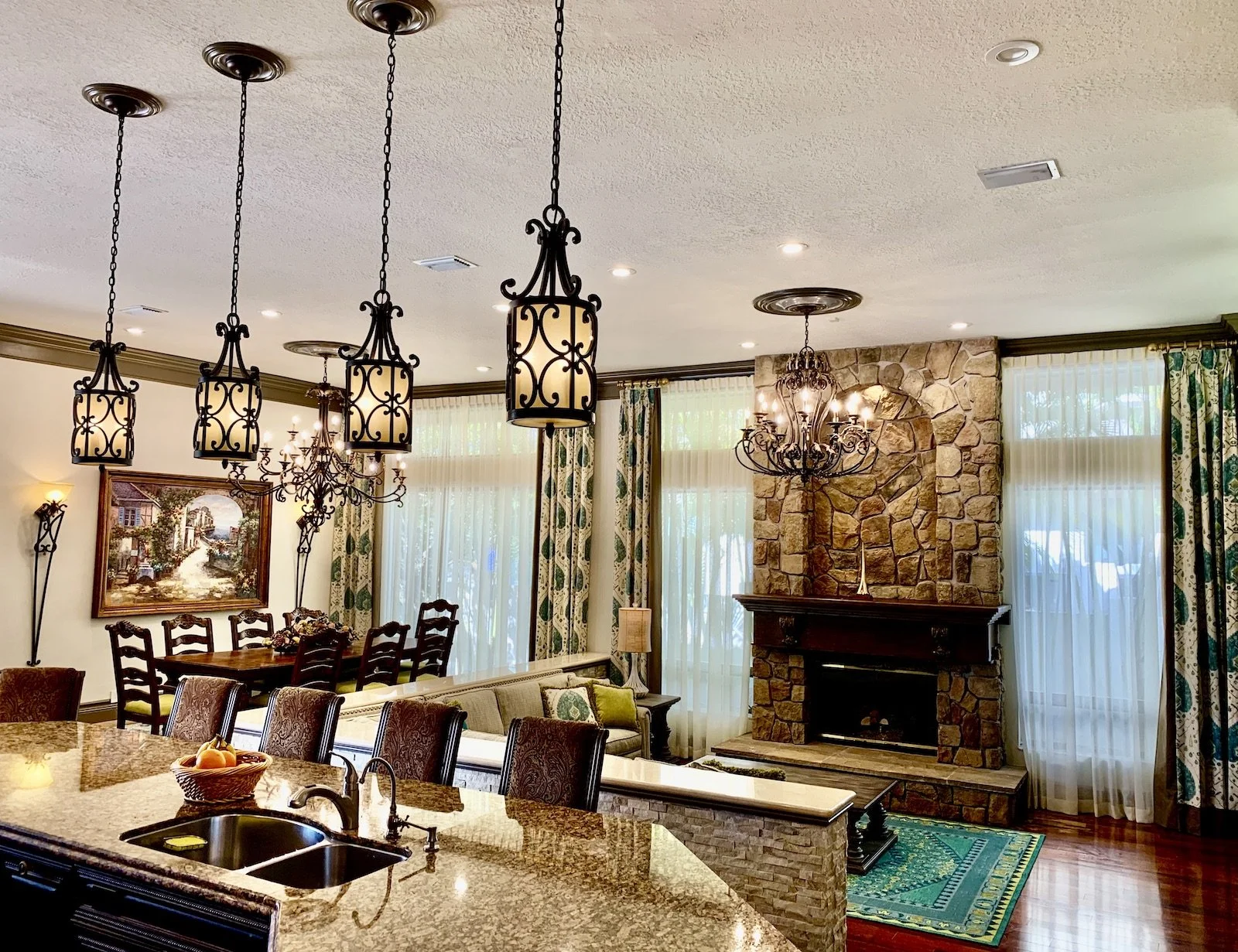 modern Mediterranean family room with fireplace and dining area with chandeliers in Boca Raton