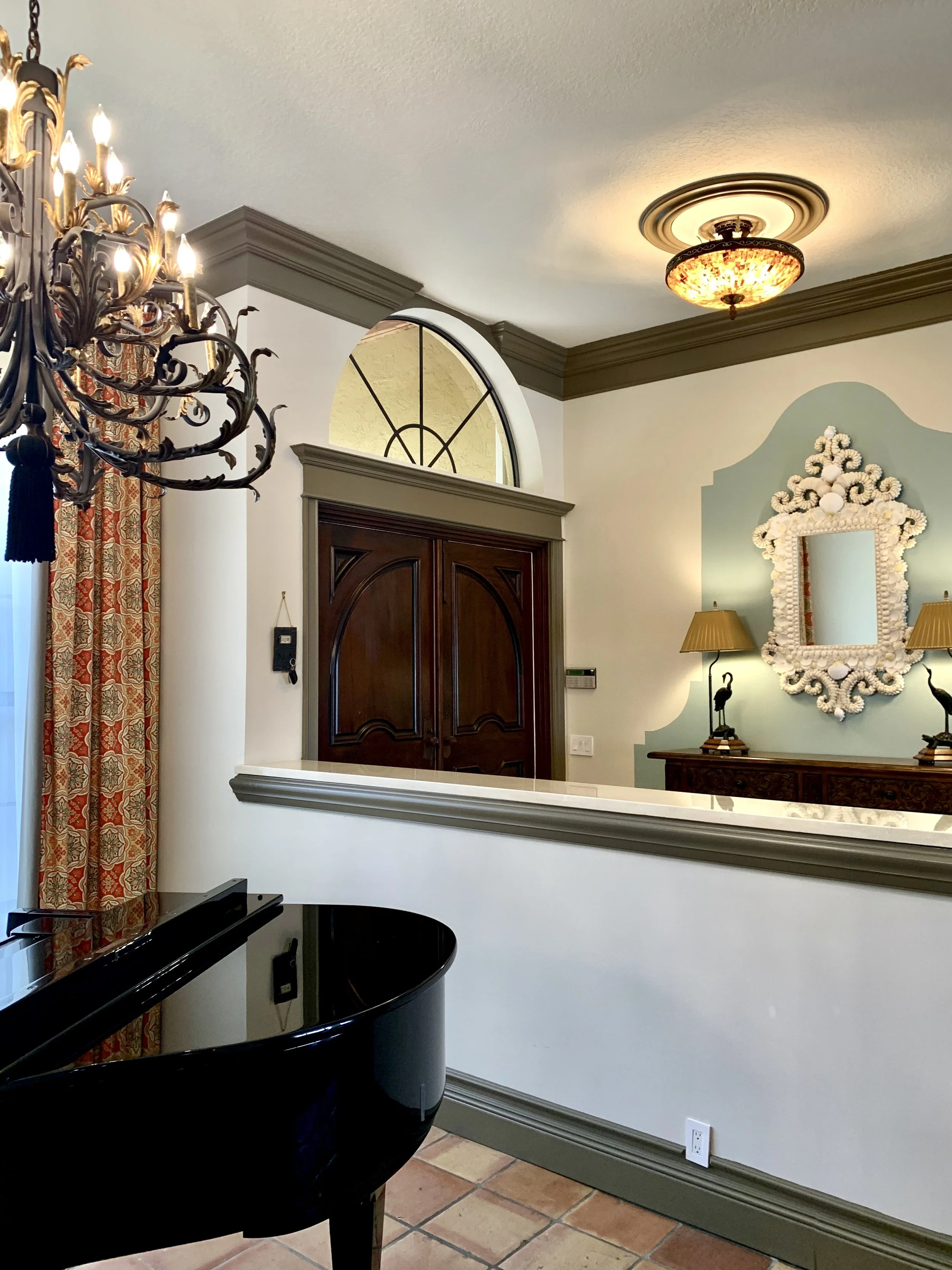 traditional interior design of foyer with grand piano and chandelier in Boca Raton