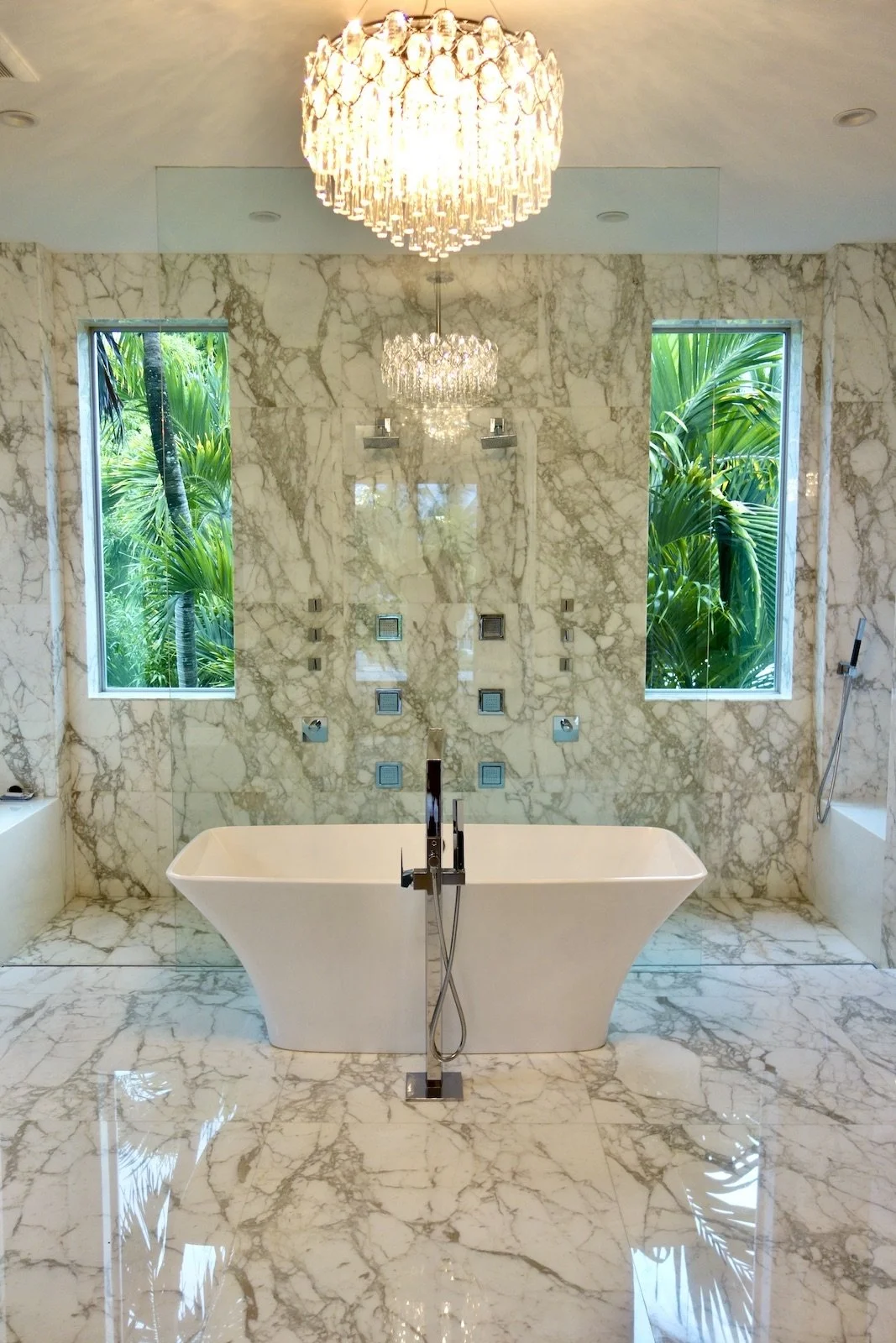 luxury marble bath room with open shower and tub with chandelier on Las Olas