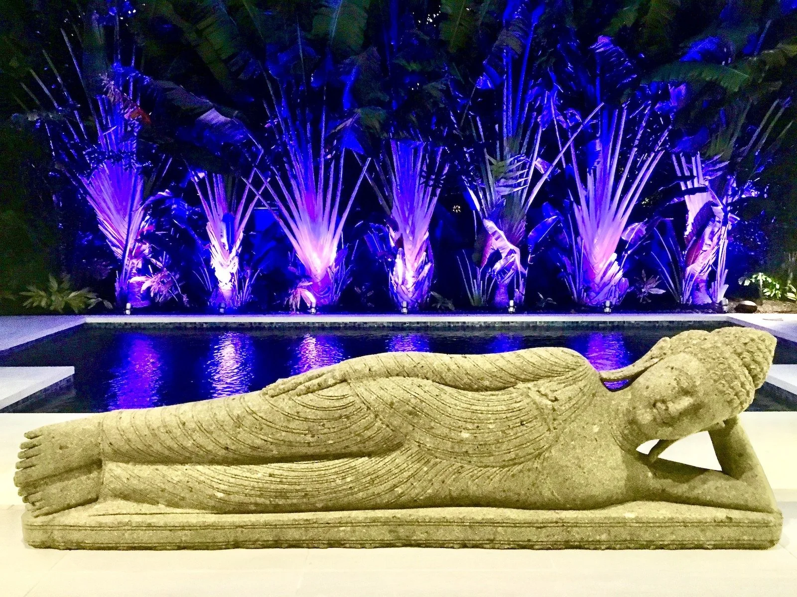 zen tropical garden with laying buddha statue by pool side in Fort Lauderdale