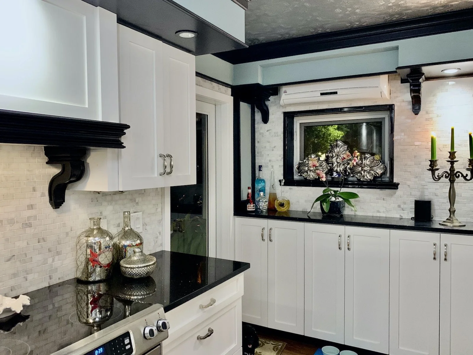 Mid Century modern black and white kitchen with Carrara marble backsplash and Black Galaxy quartz counters