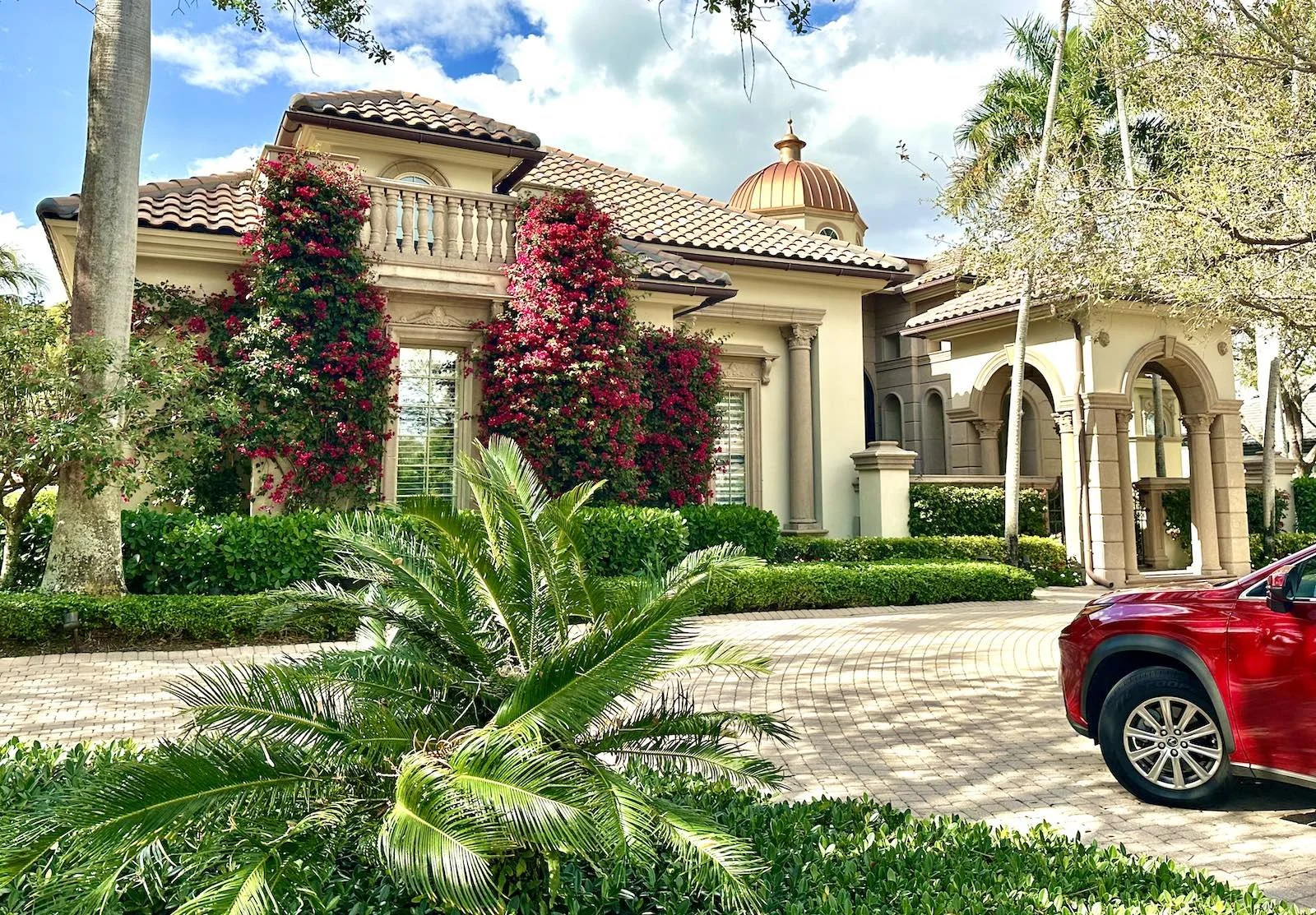 front of a home with mediterranean architecture showing stone arches and columns at courtyard in palm beach