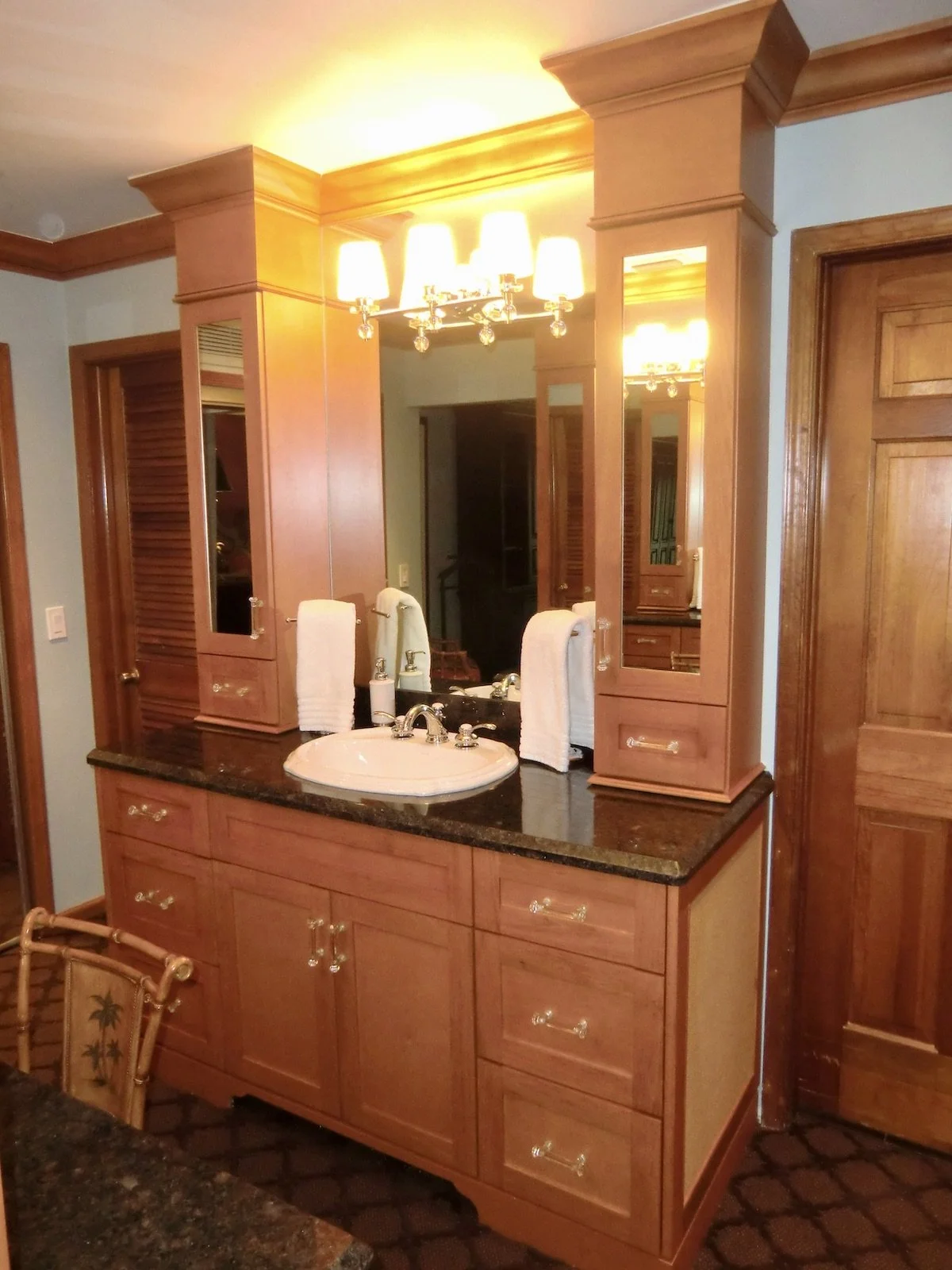 home remodel of traditional bathroom sink vanity with flanking upper cabinets to ceiling with traditional moldings
