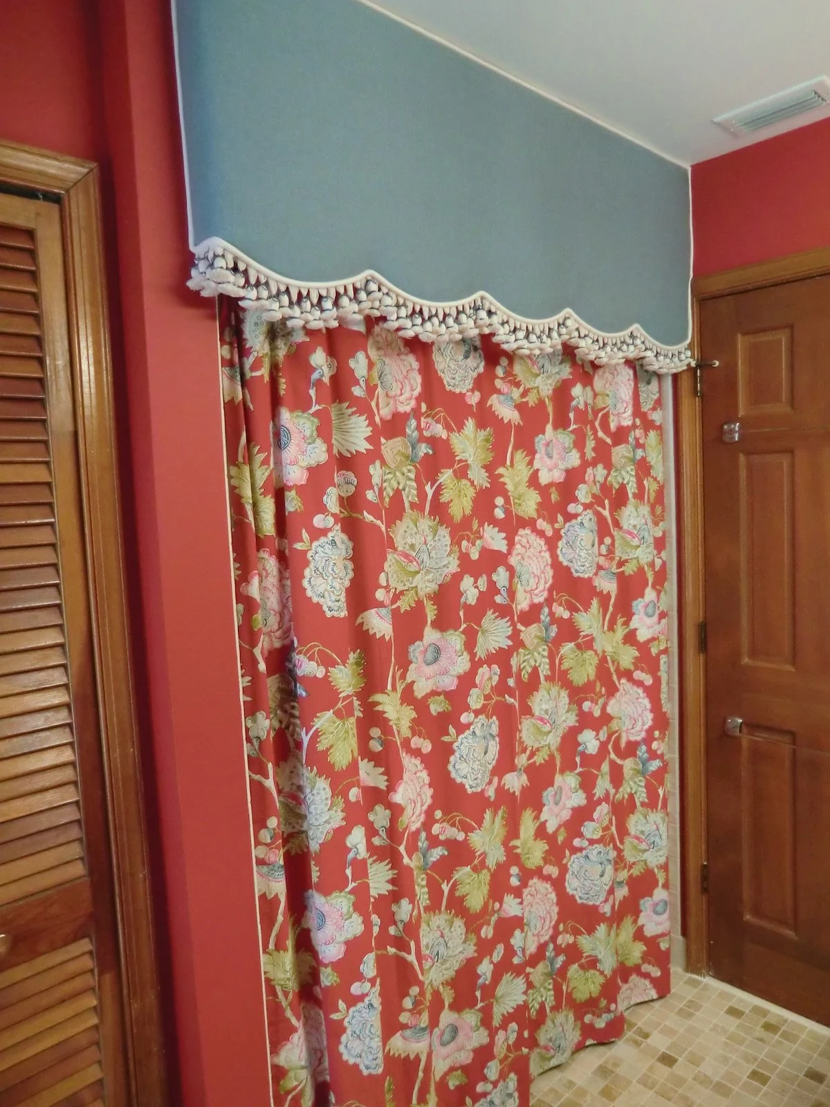 Delray Beach guest bathroom with red walls and custom drapery with tropical red fabric and blue valance