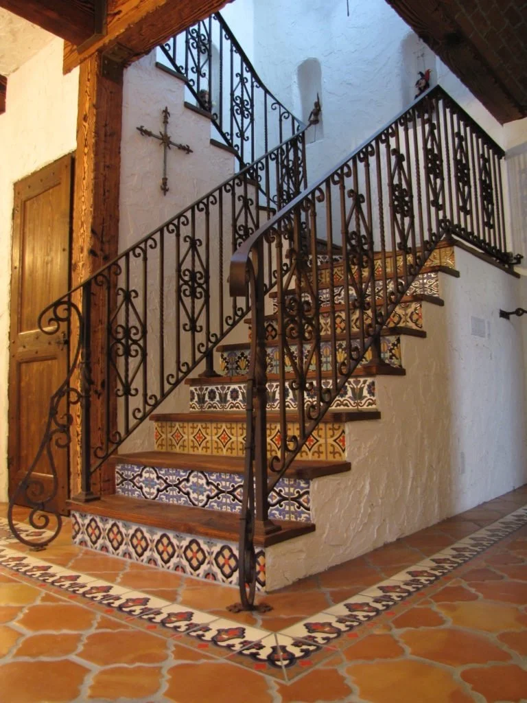 Mediterranean Revival staircase in a Boca Raton's home with decorative wrought iron and architectural detailing