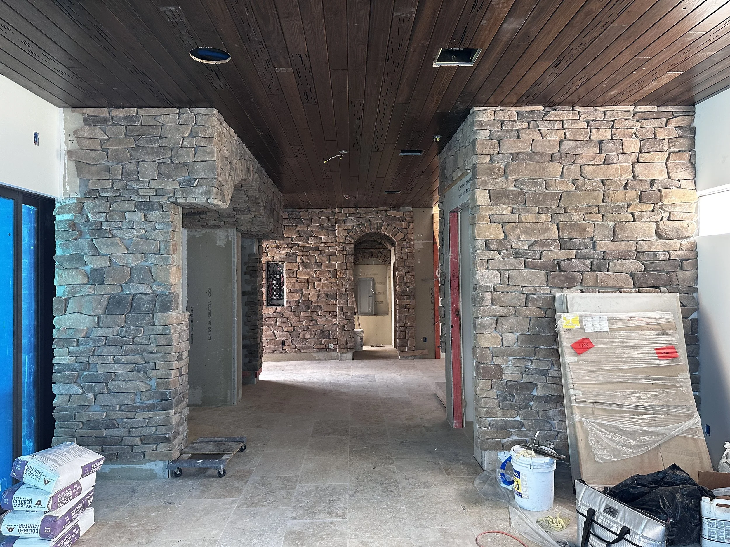 before of Mediterranean great room showing stone walls and arched ceiling in kitchen