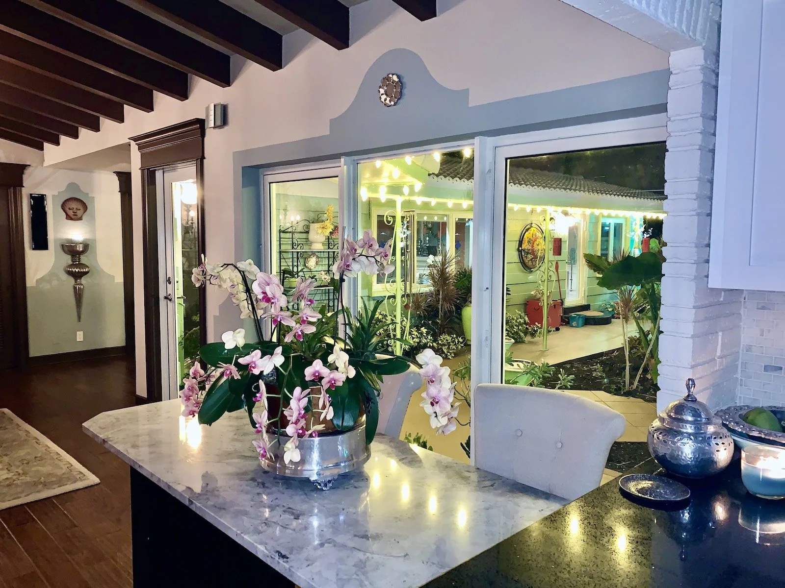 Transitional Mediterranean dining area with marble top table and view of garden