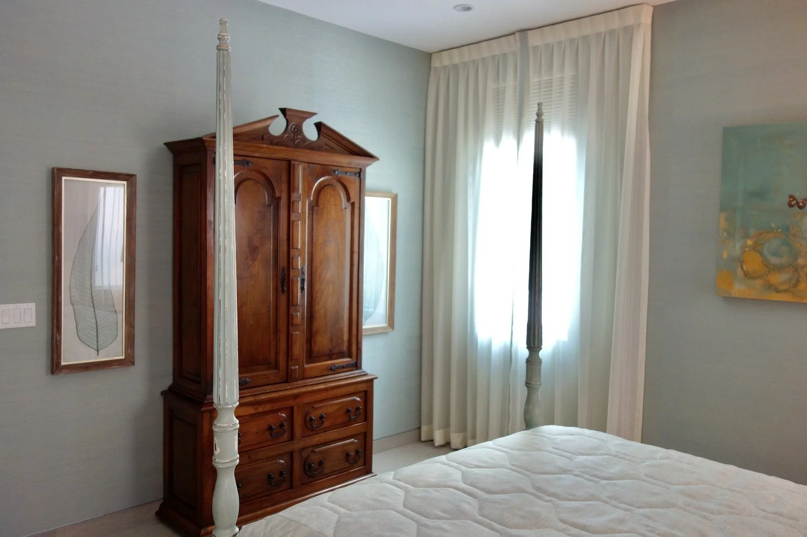 luxury tropical bedroom with four poster bed and antique armoire in Fort Lauderdale