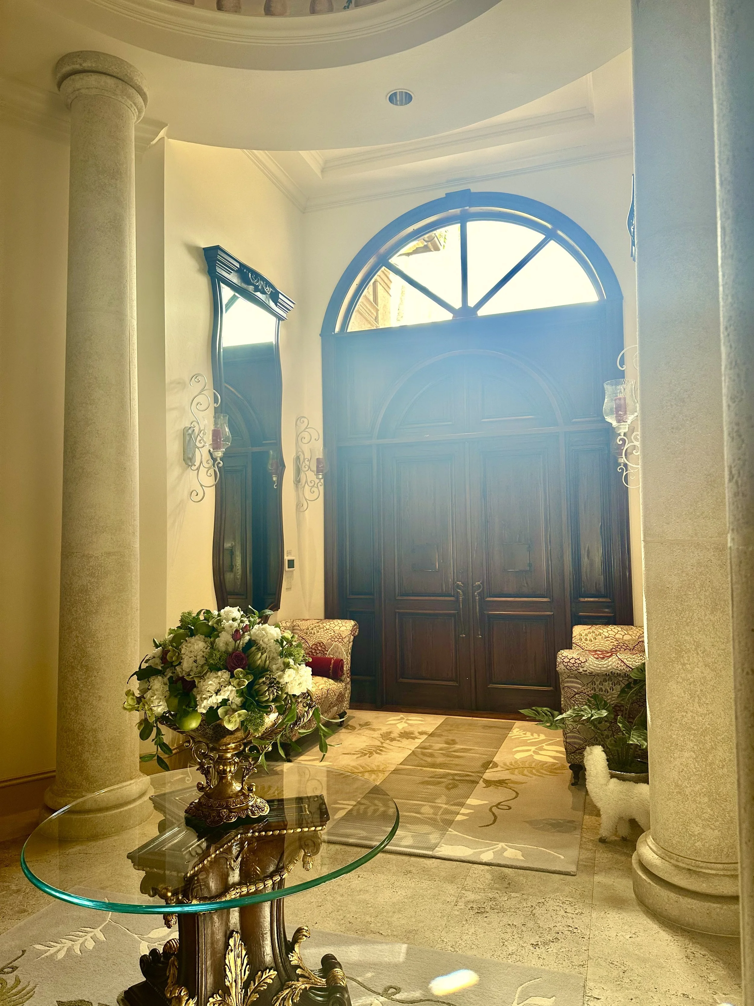 Mediterranean foyer with stone columns and rustic wood doors