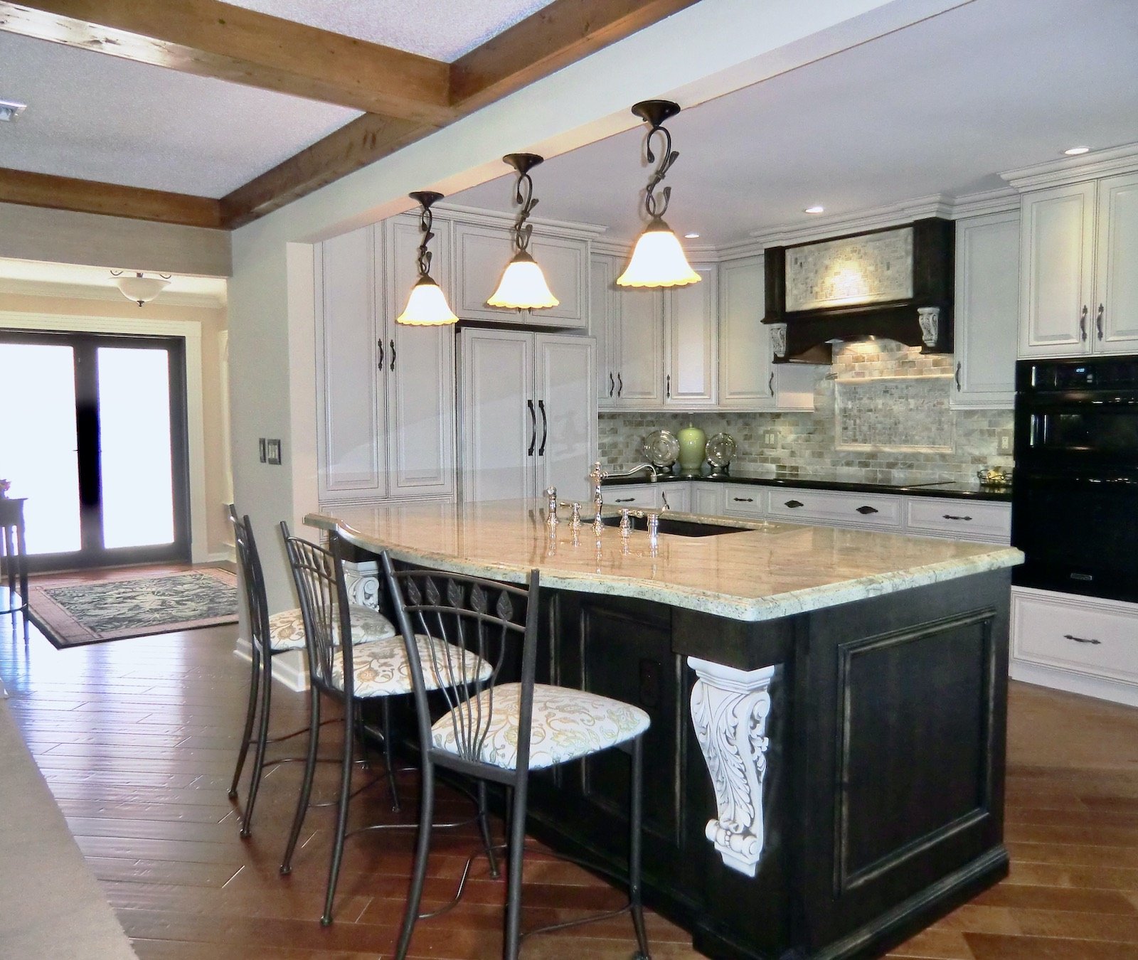 Traditional kitchen remodel with black island and cream corbels in Delray Beach