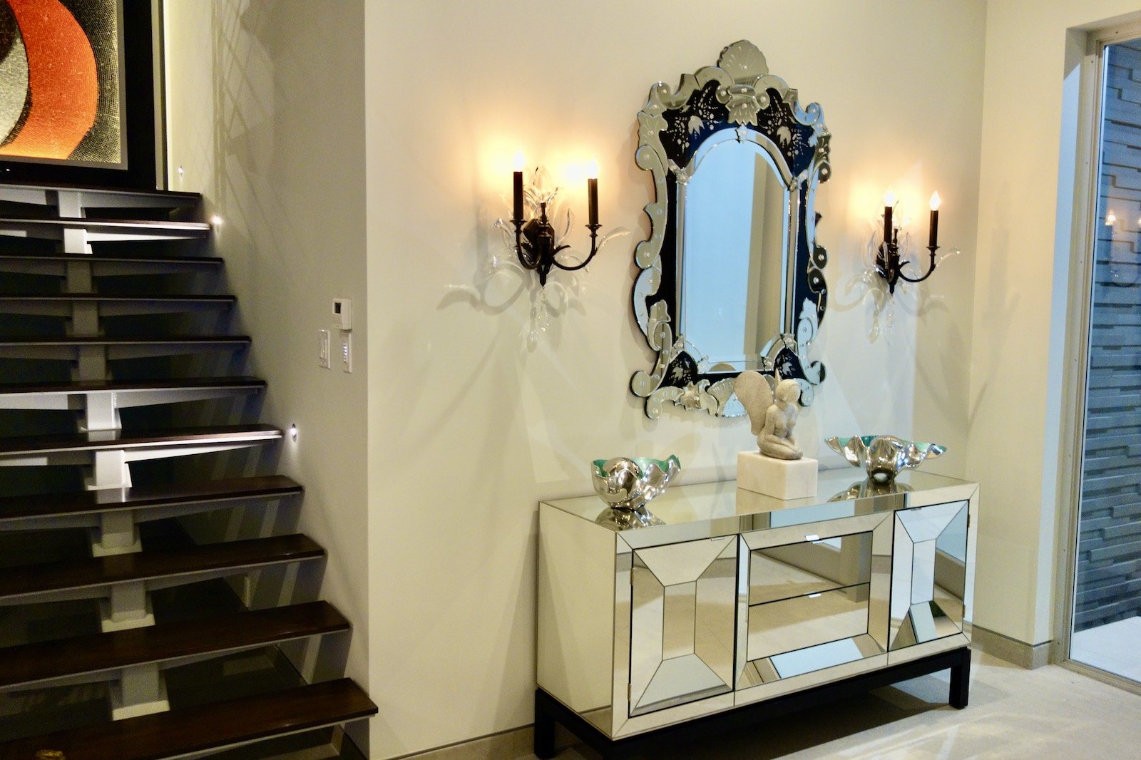 modern foyer with mirror console with traditional sconces flanking a Venetian mirror near Fort Lauderdale Beach