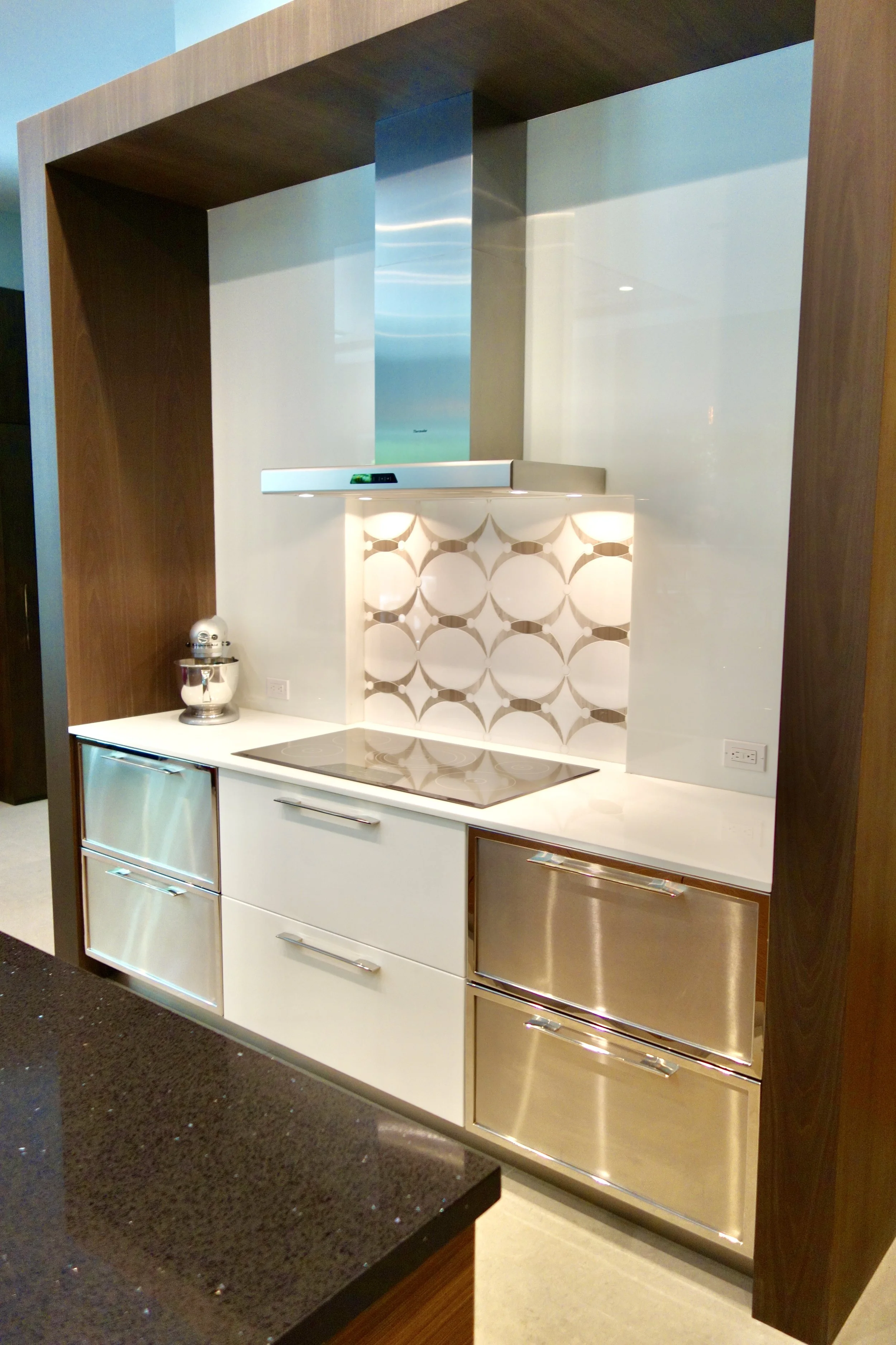 modern kitchen remodel with cook top feature wall with large dark wood bridge in Fort Lauderdale
