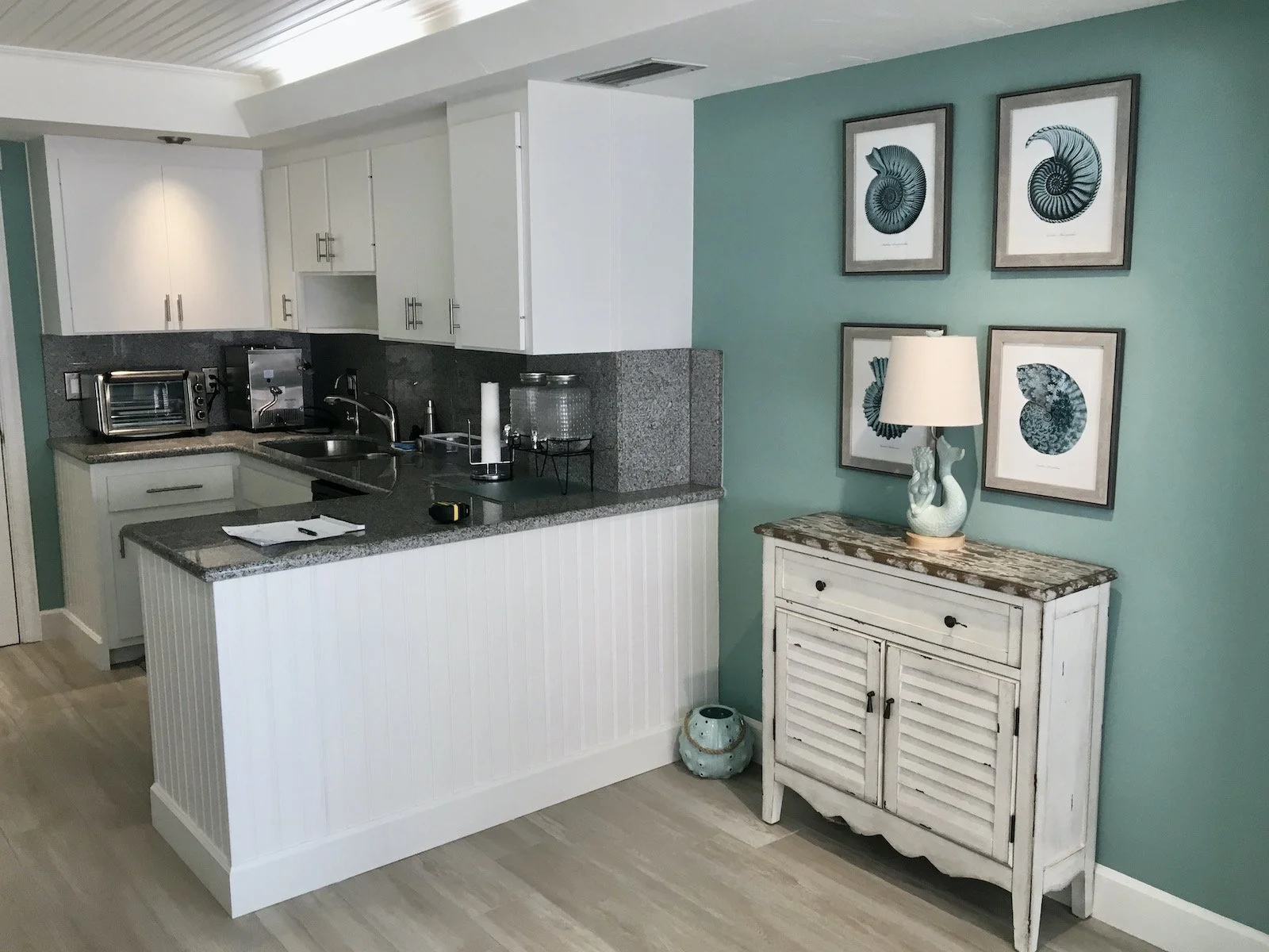 coastal kitchen with aqua green walls, white cabinets, and bead board ceiling at Ocean Reef Club