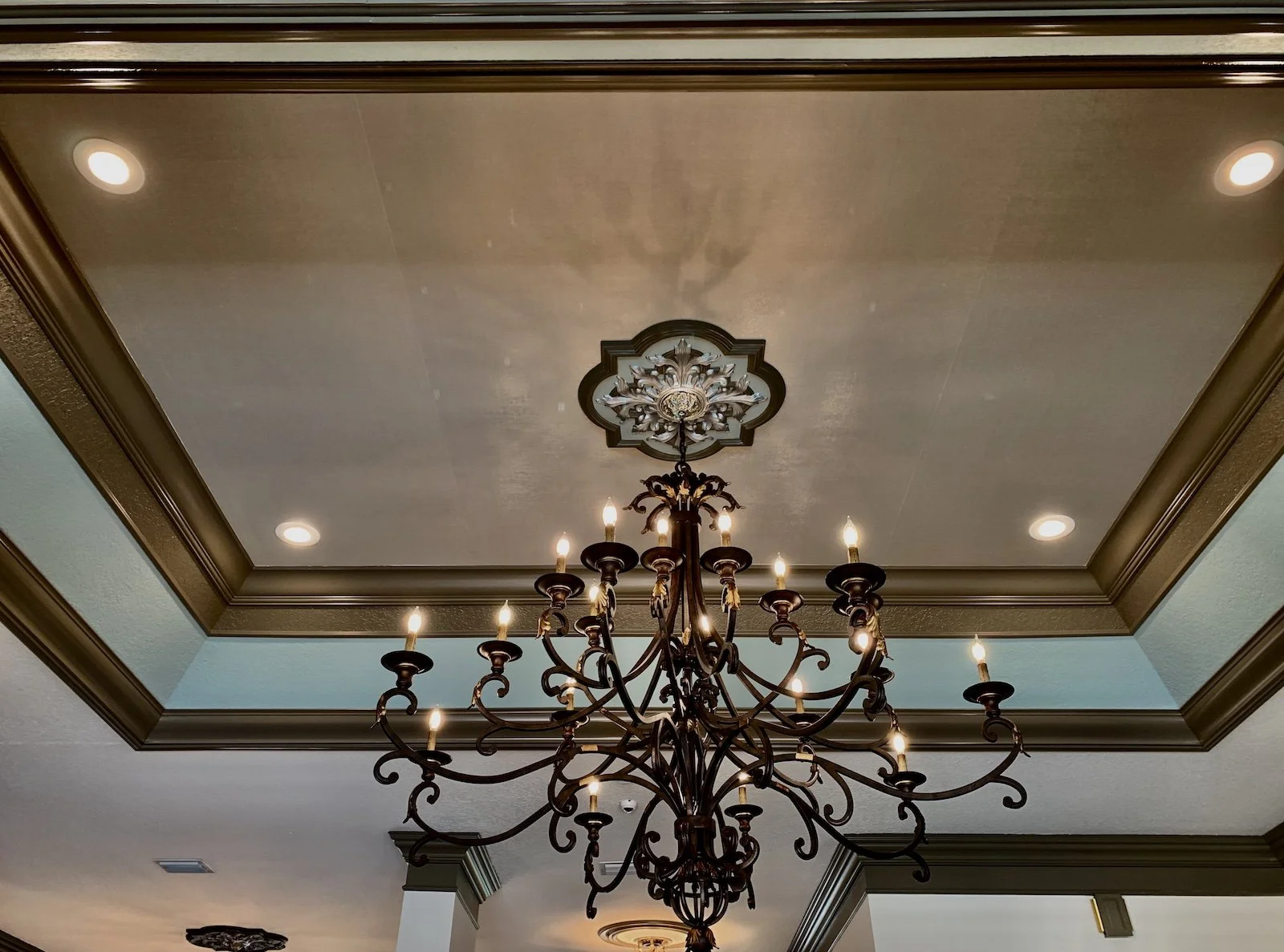 Mediterranean living room. with wrought Iron Chandelier in silver tray ceiling
