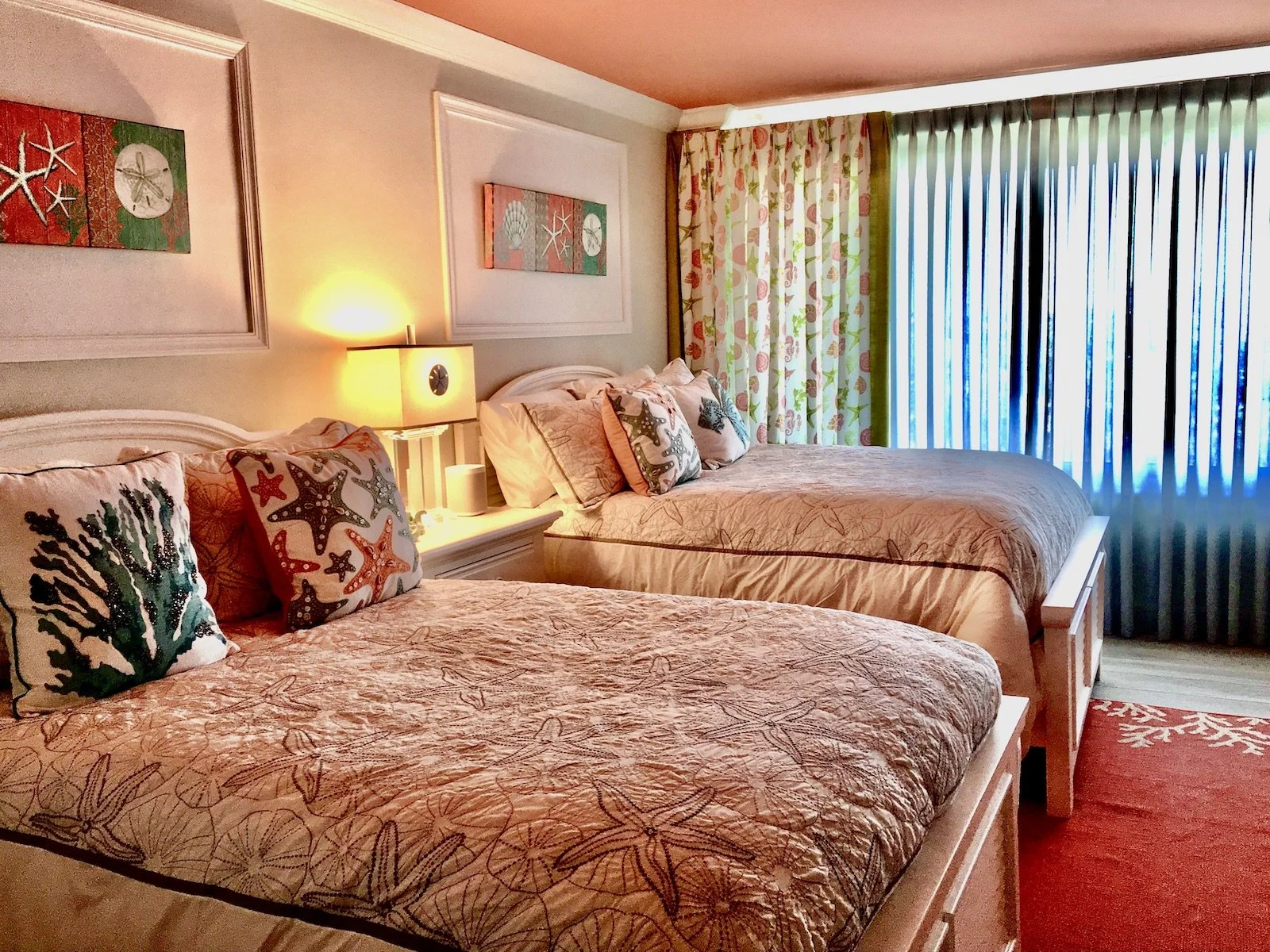 coastal bedroom with two beds with tropical starfish bedding and a coral ceiling in Florida Keys