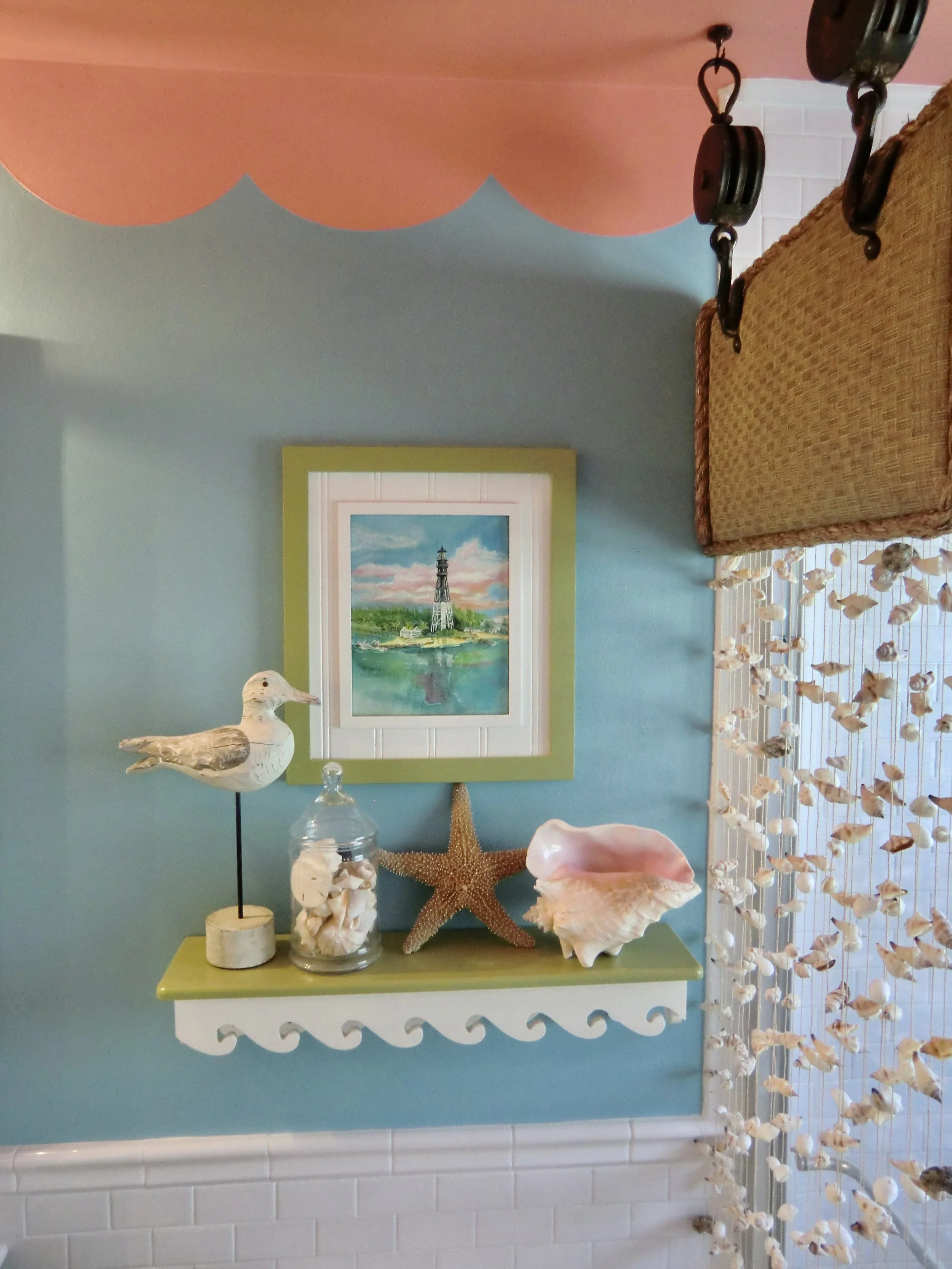 Colorful tropical bathroom with aqua walls, coral ceiling, and shell drapes shower enclosure