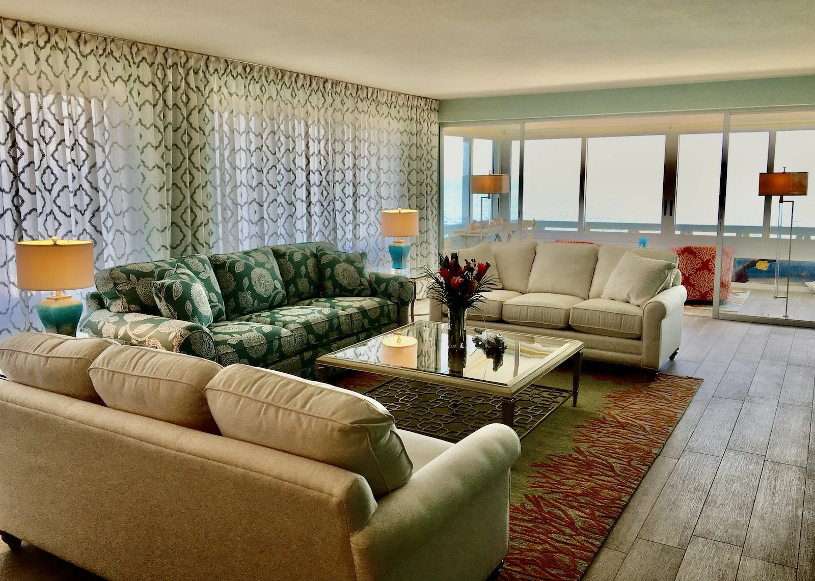 tropical living room with three sofa and large windows over looking the ocean at ocean reef club