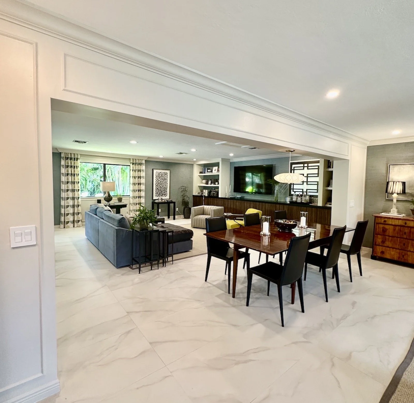 great room with mid century dining table and chairs with modern lighting