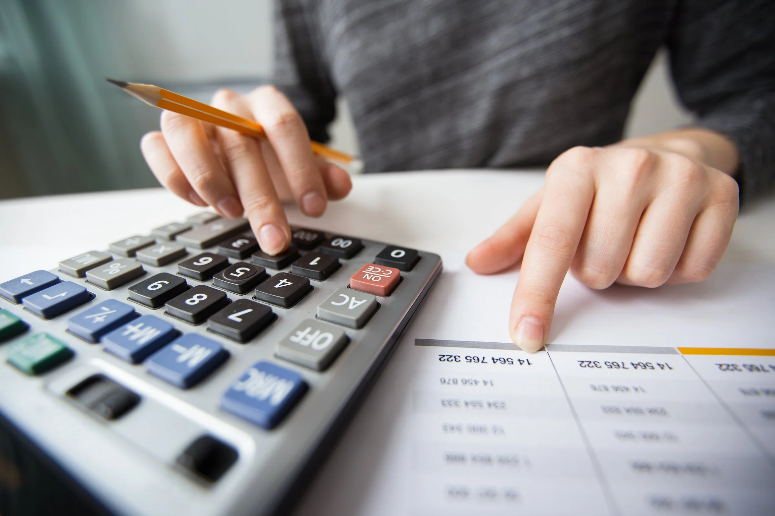 Photo of a person calculating import duty tax with a calculator