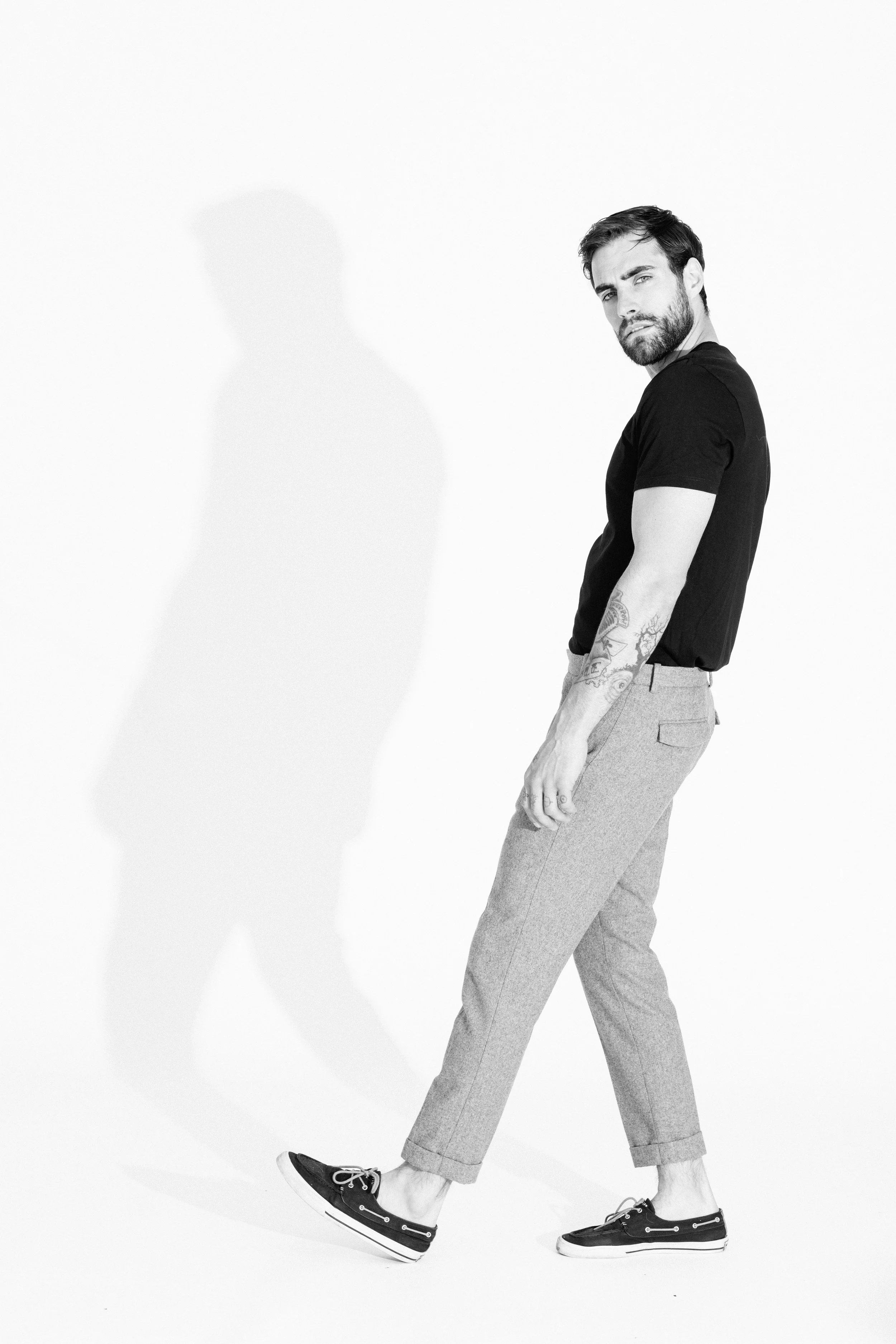 Black and white studio portrait of a male model using dramatic light and shadow, photographed by Vancouver commercial photographer Anick Violette.