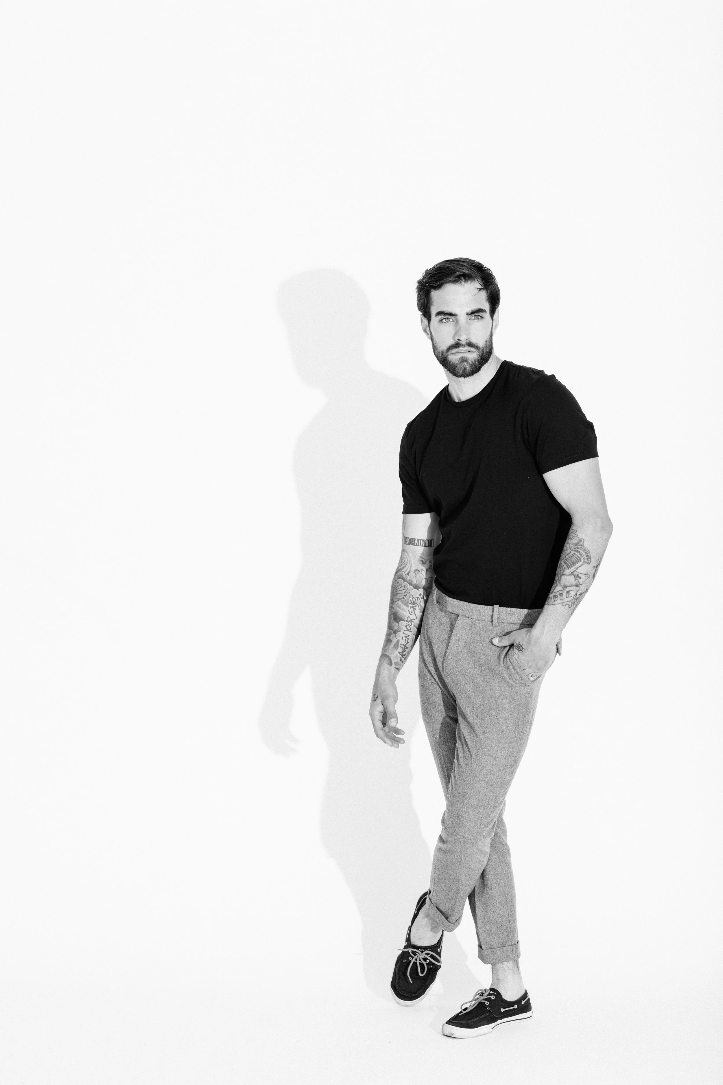 Black and white studio portrait of a male model using dramatic light and shadow, photographed by Vancouver commercial photographer Anick Violette.