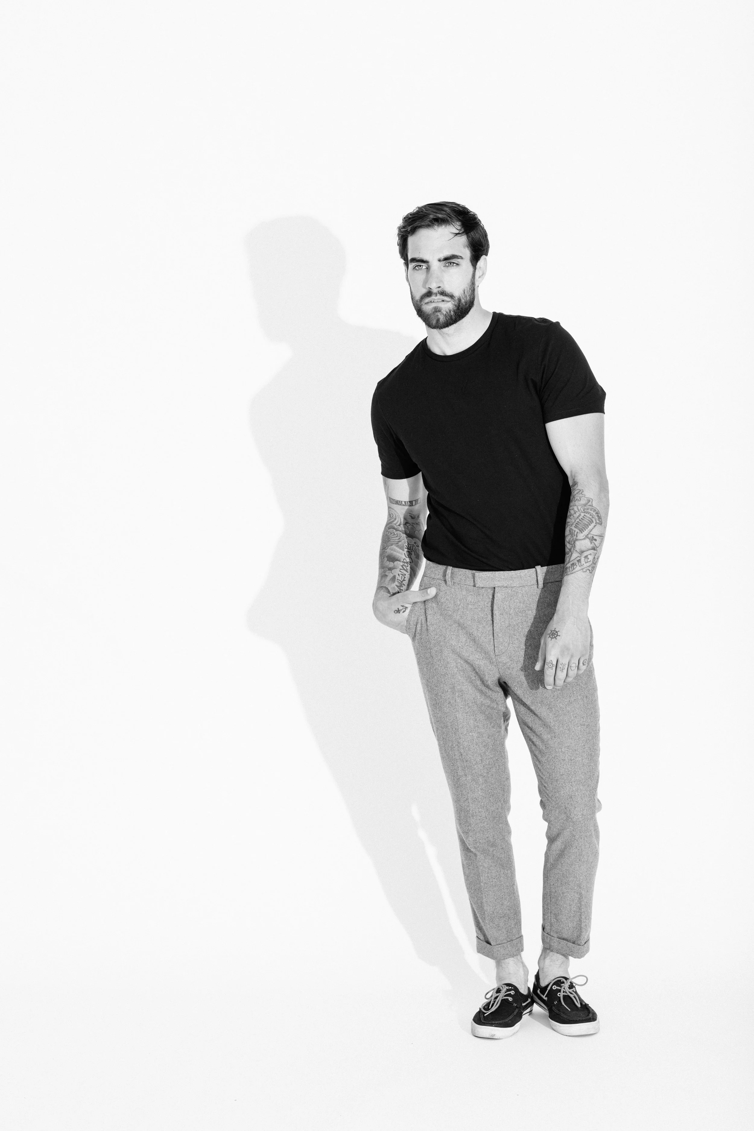 Black and white studio portrait of a male model using dramatic light and shadow, photographed by Vancouver commercial photographer Anick Violette.