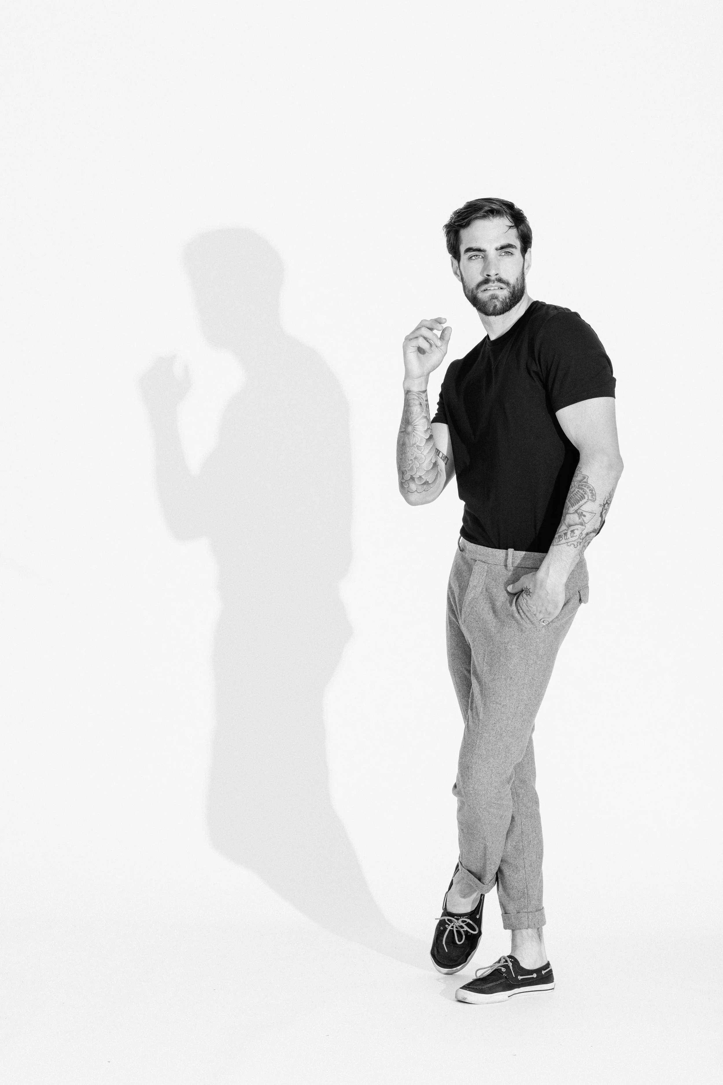 Black and white studio portrait of a male model using dramatic light and shadow, photographed by Vancouver commercial photographer Anick Violette.