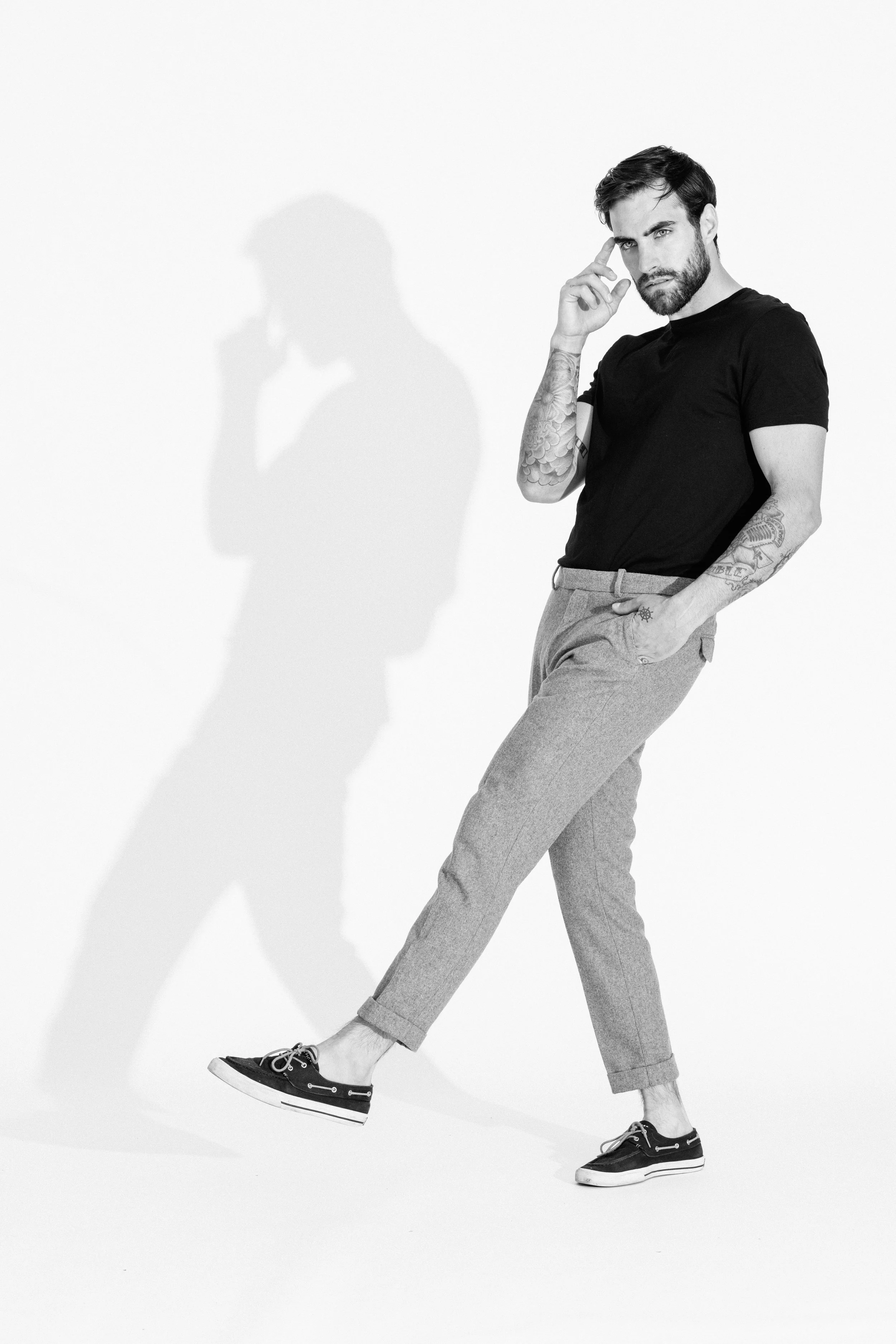 Black and white studio portrait of a male model using dramatic light and shadow, photographed by Vancouver commercial photographer Anick Violette.