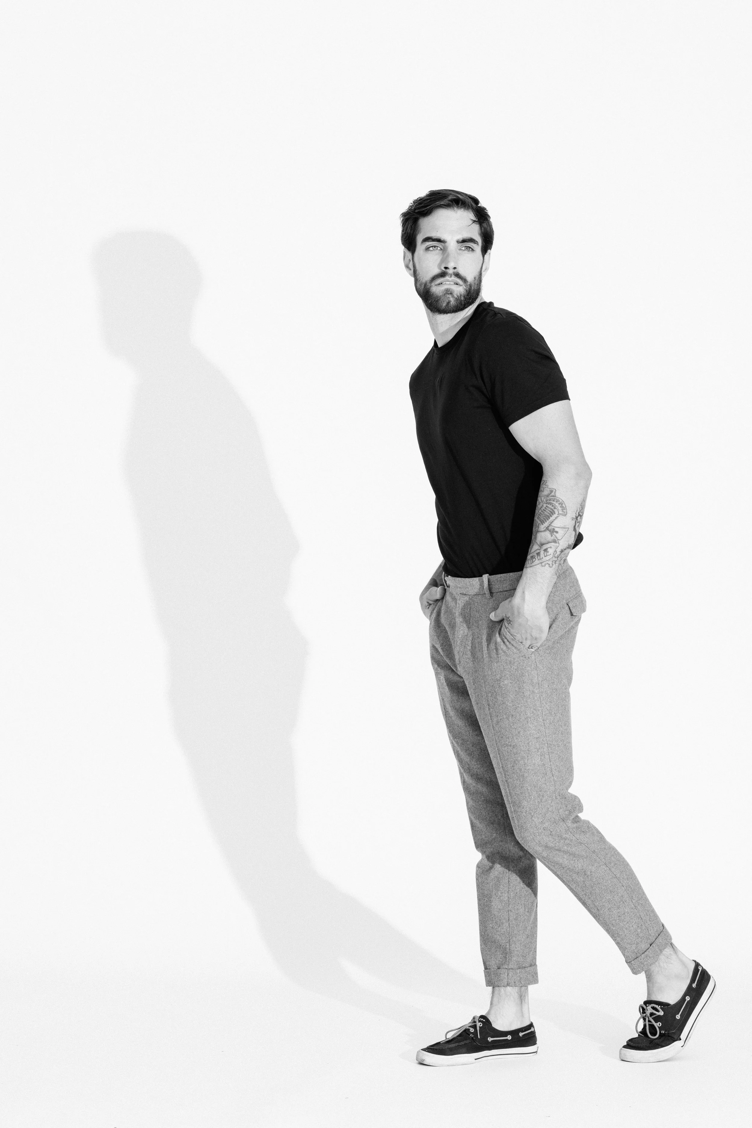 Black and white studio portrait of a male model using dramatic light and shadow, photographed by Vancouver commercial photographer Anick Violette.