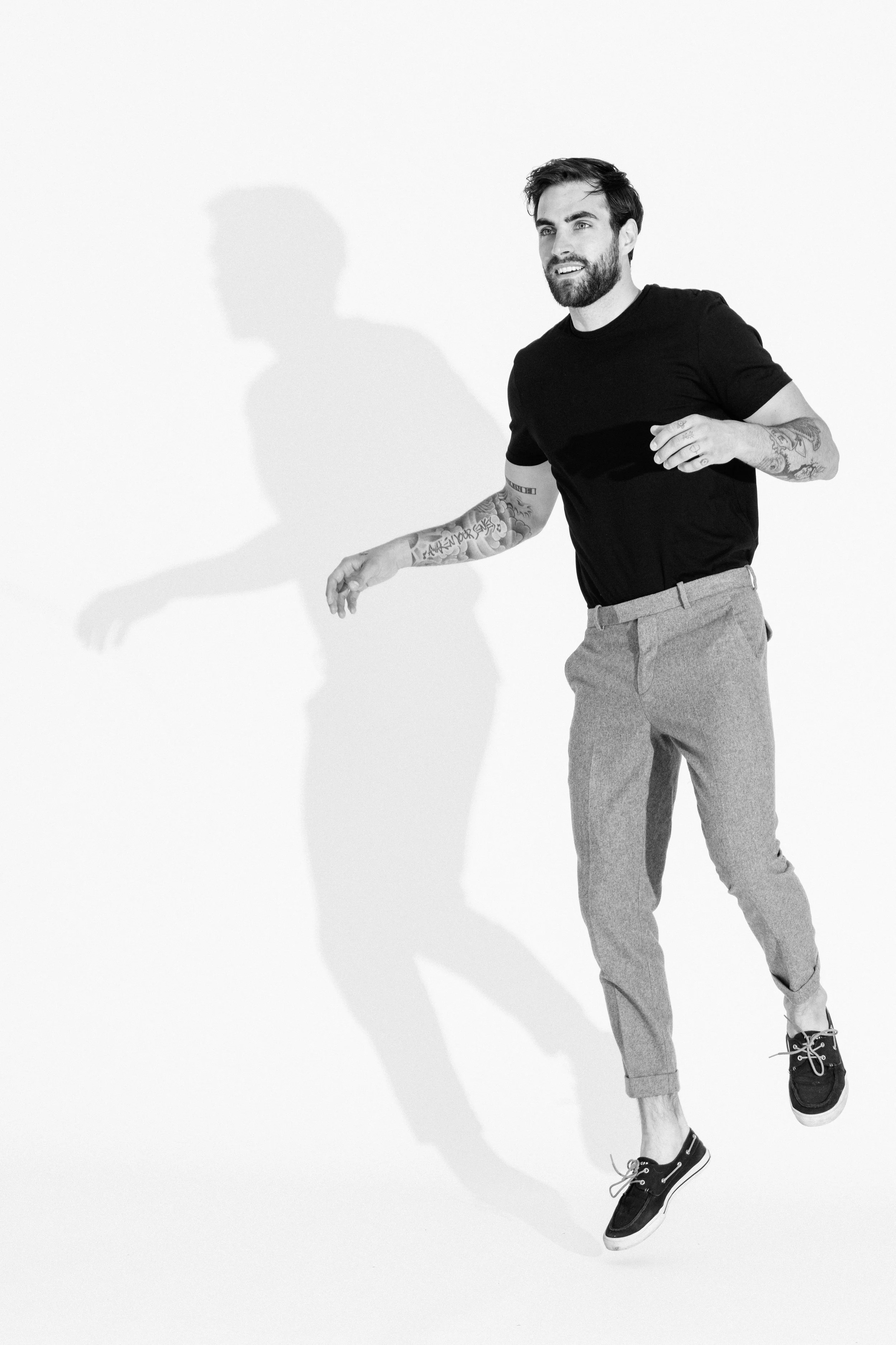 Black and white studio portrait of a male model using dramatic light and shadow, photographed by Vancouver commercial photographer Anick Violette.