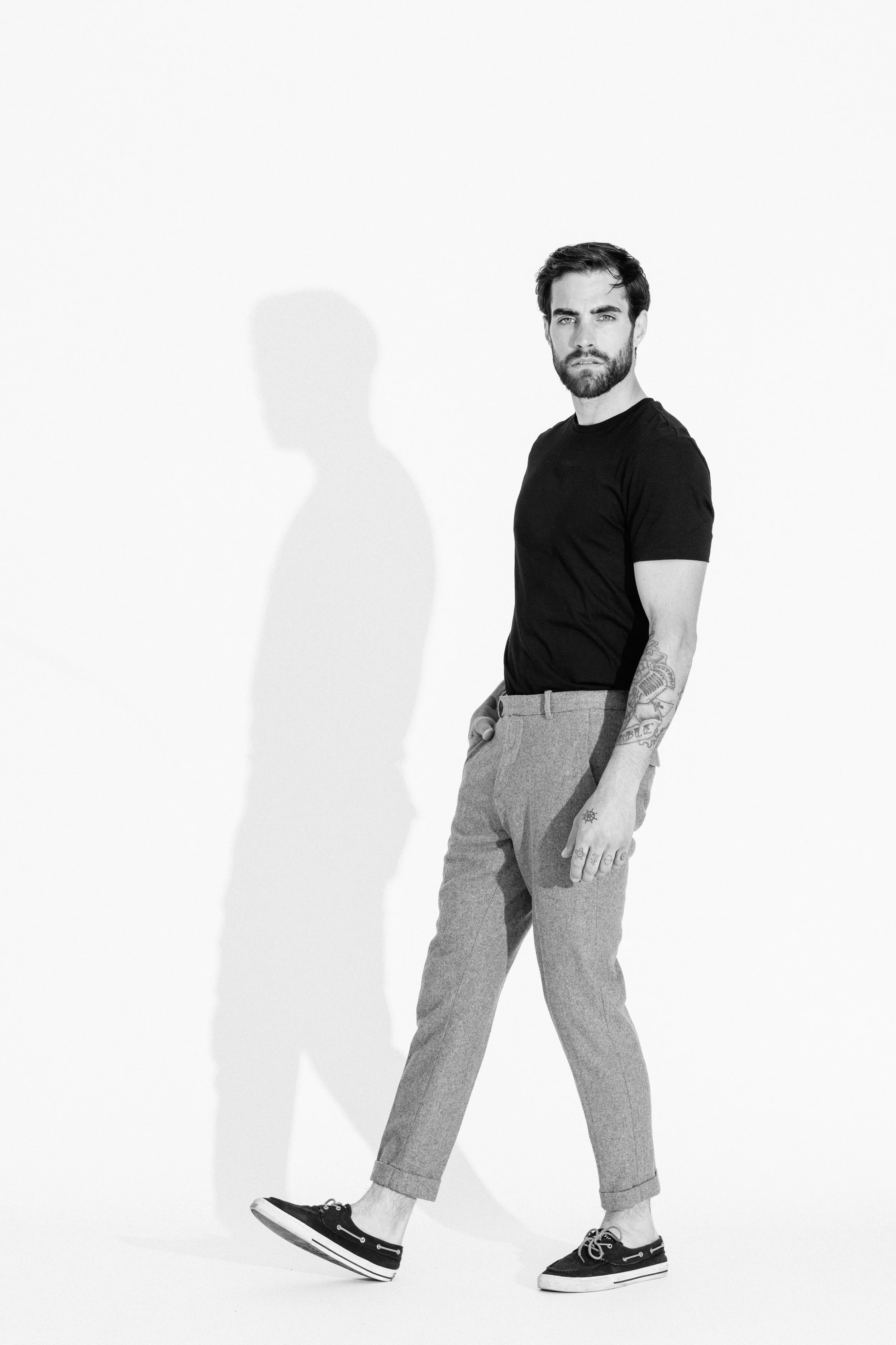 Black and white studio portrait of a male model using dramatic light and shadow, photographed by Vancouver commercial photographer Anick Violette.