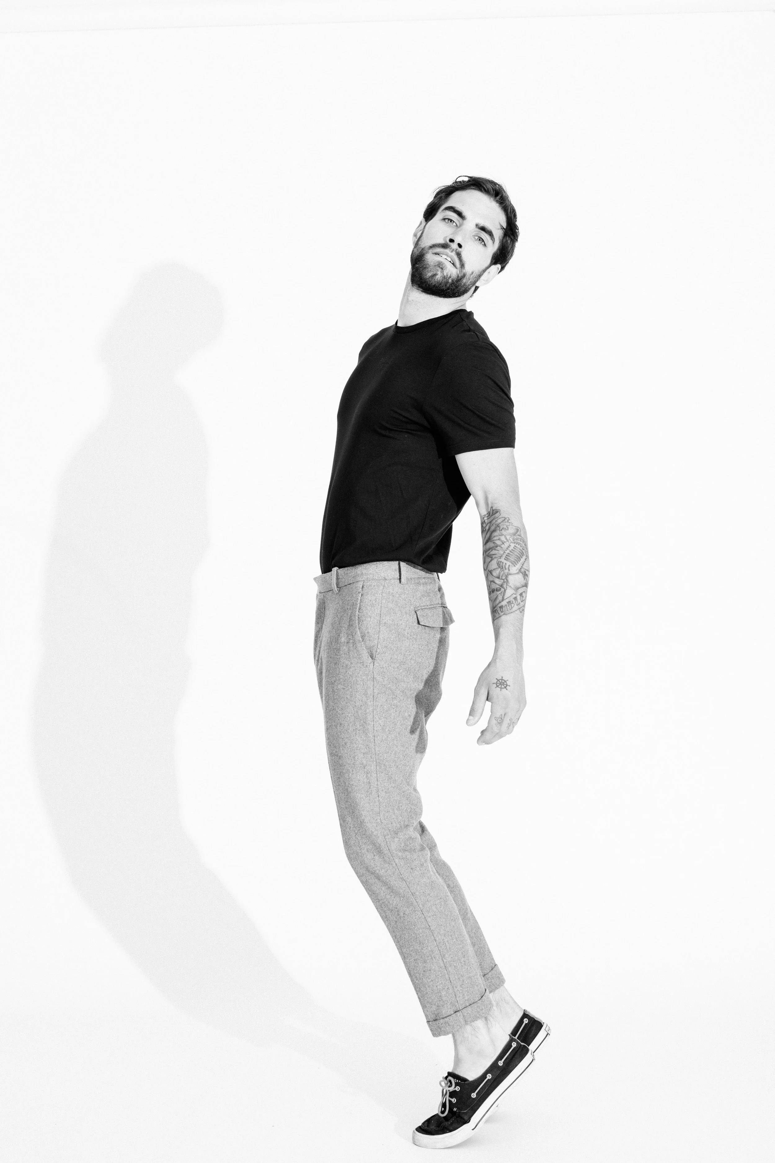 Black and white studio portrait of a male model using dramatic light and shadow, photographed by Vancouver commercial photographer Anick Violette.