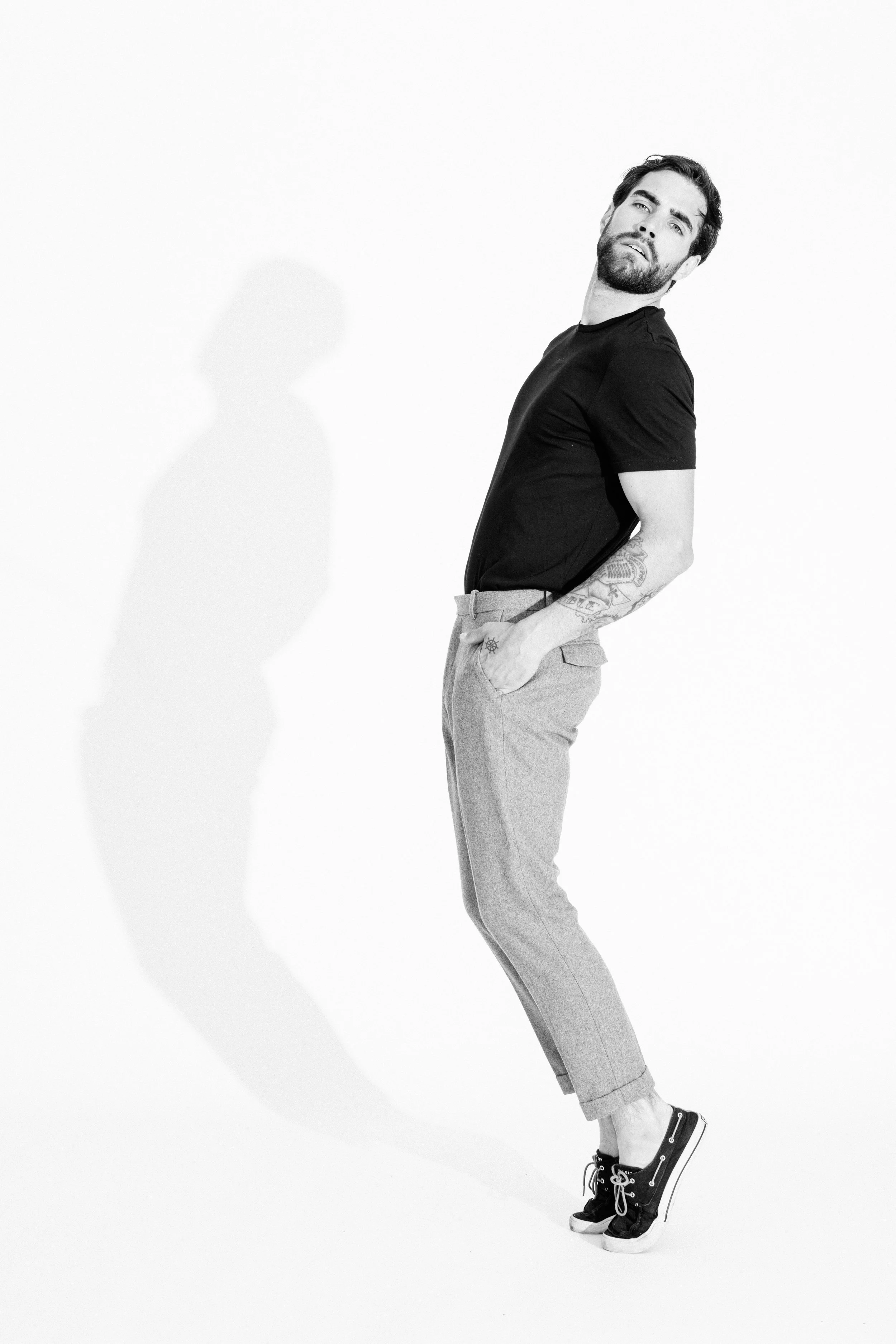 Black and white studio portrait of a male model using dramatic light and shadow, photographed by Vancouver commercial photographer Anick Violette.