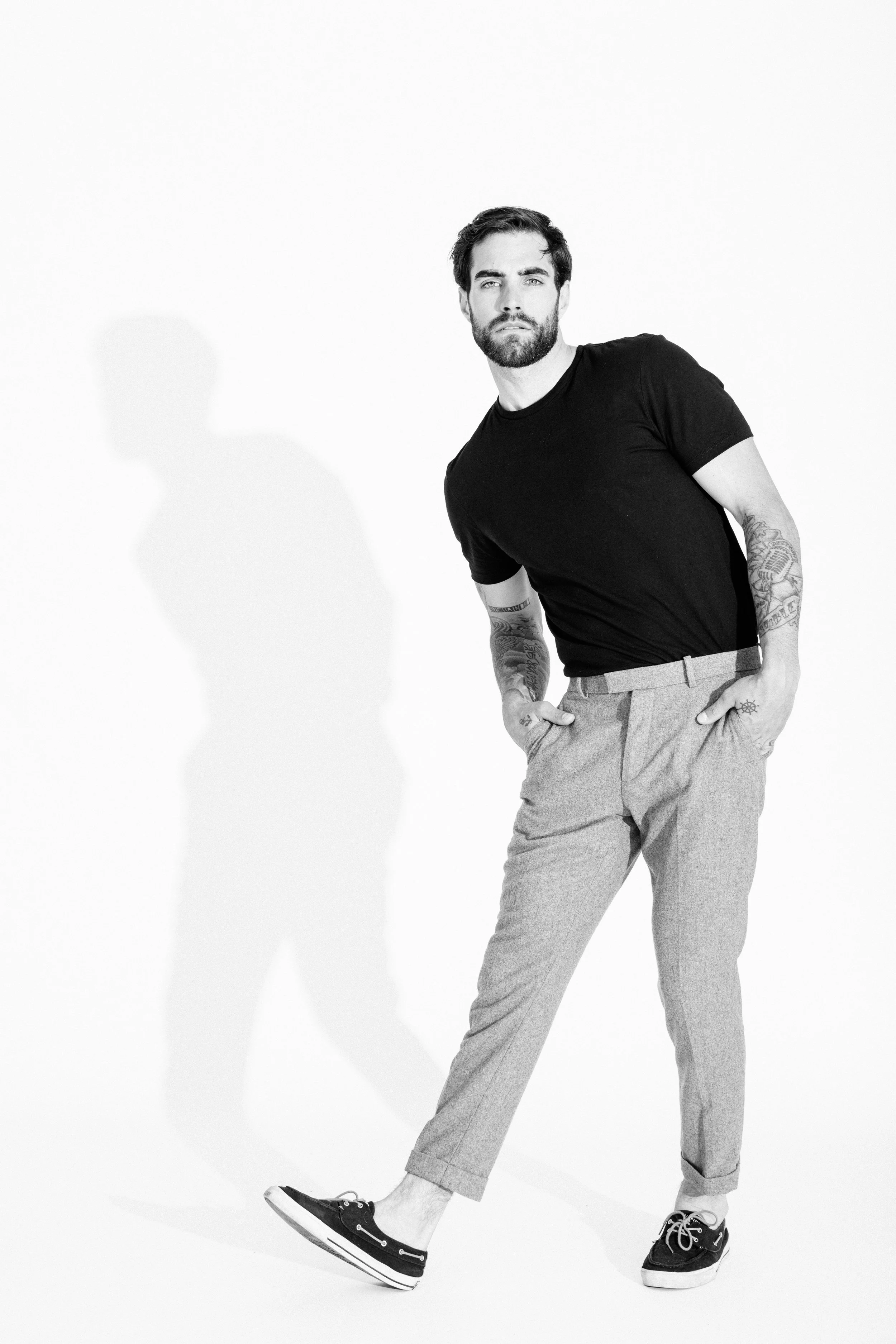 Black and white studio portrait of a male model using dramatic light and shadow, photographed by Vancouver commercial photographer Anick Violette.