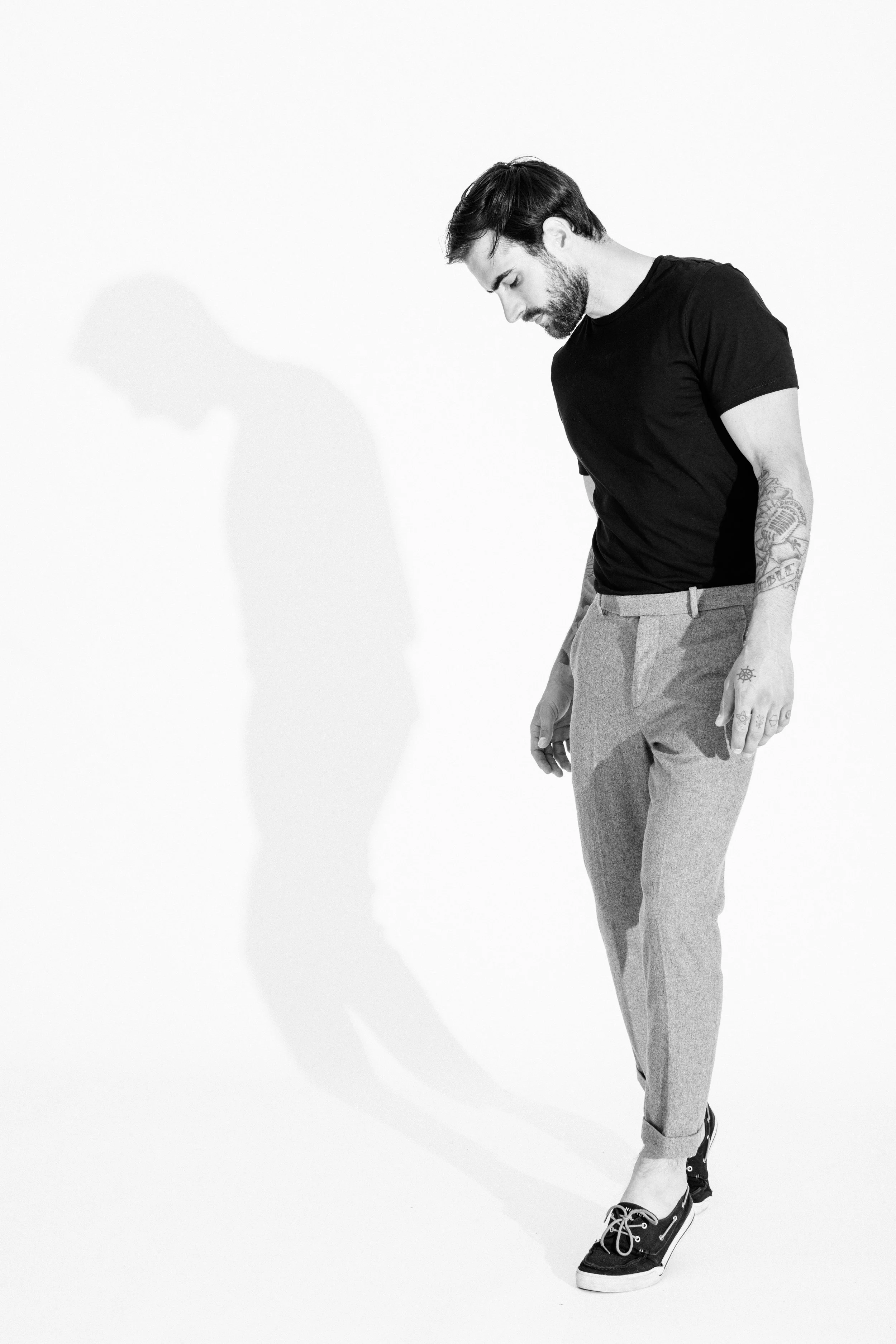 Black and white studio portrait of a male model using dramatic light and shadow, photographed by Vancouver commercial photographer Anick Violette.