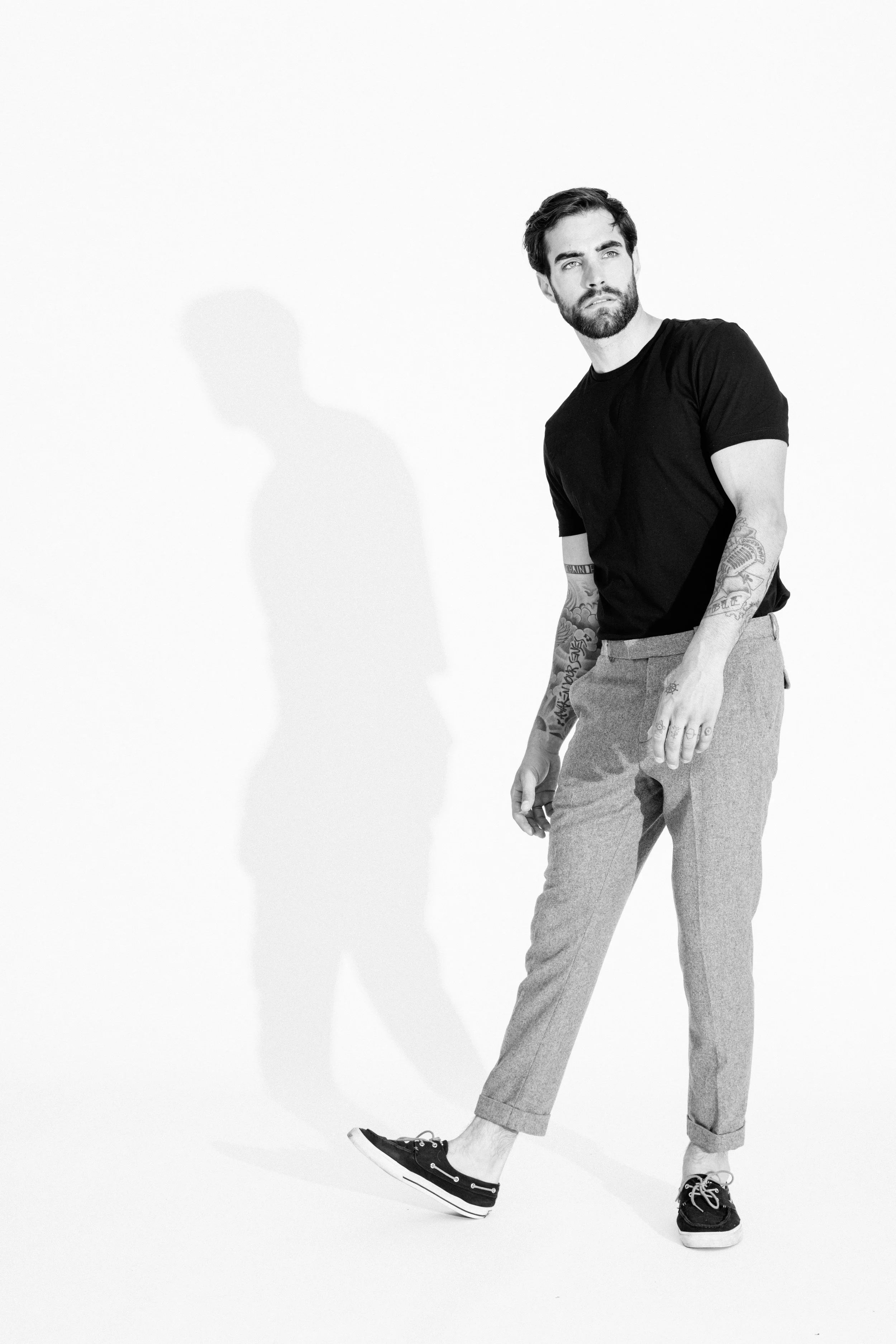 Black and white studio portrait of a male model using dramatic light and shadow, photographed by Vancouver commercial photographer Anick Violette.