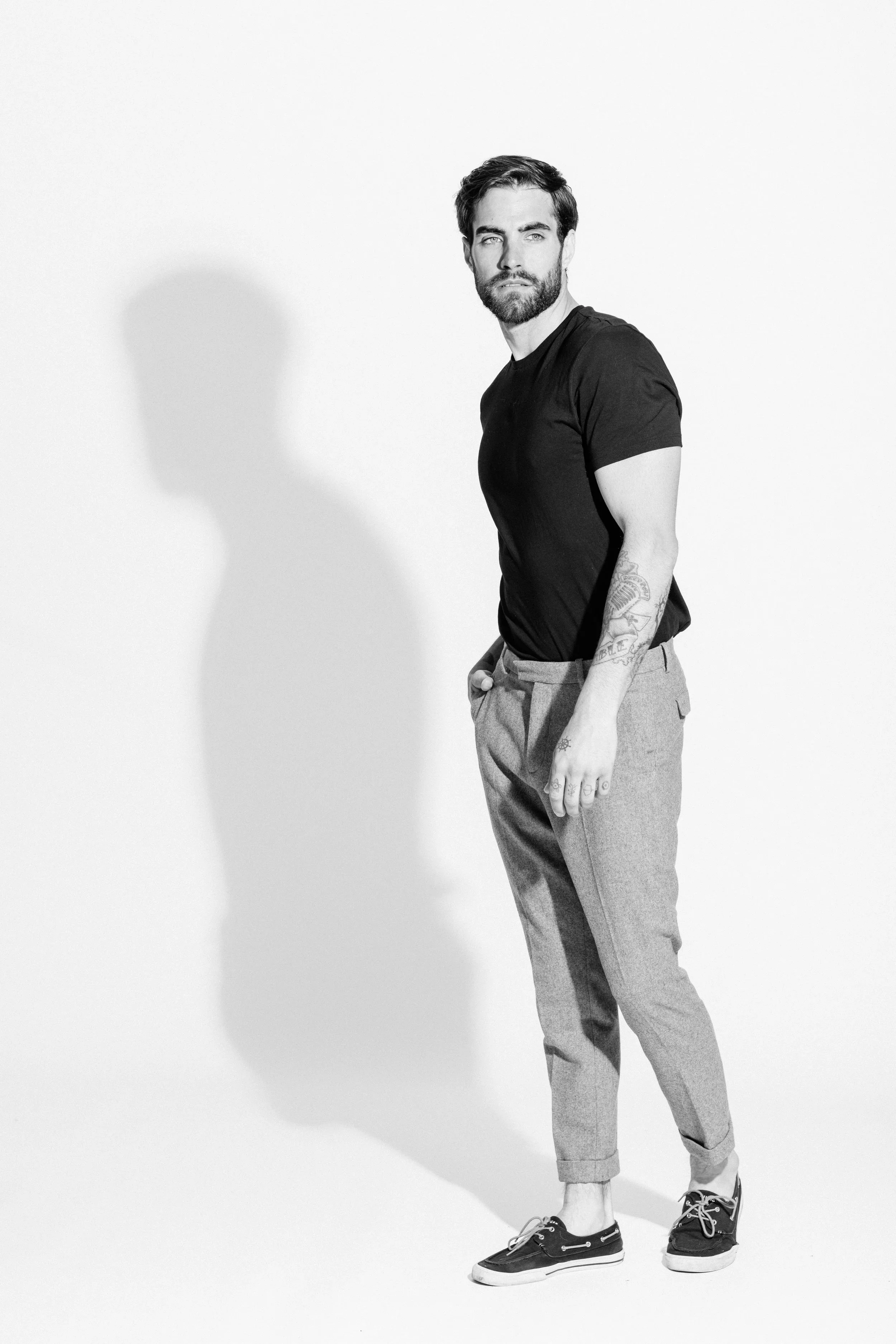 Black and white studio portrait of a male model using dramatic light and shadow, photographed by Vancouver commercial photographer Anick Violette.