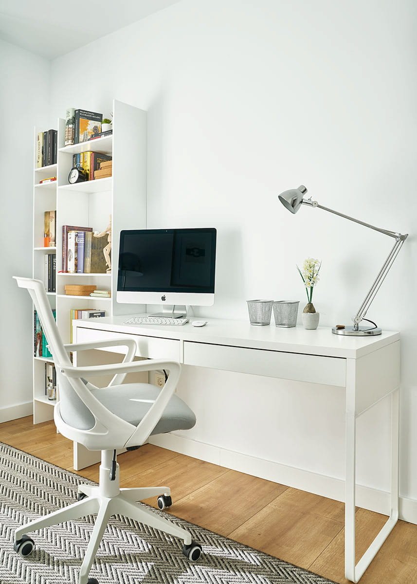Escritorio blanco en despacho moderno con estantería y ordenador en vivienda en Urduliz Bizkaia proyecto de interiorismo y estilismo.