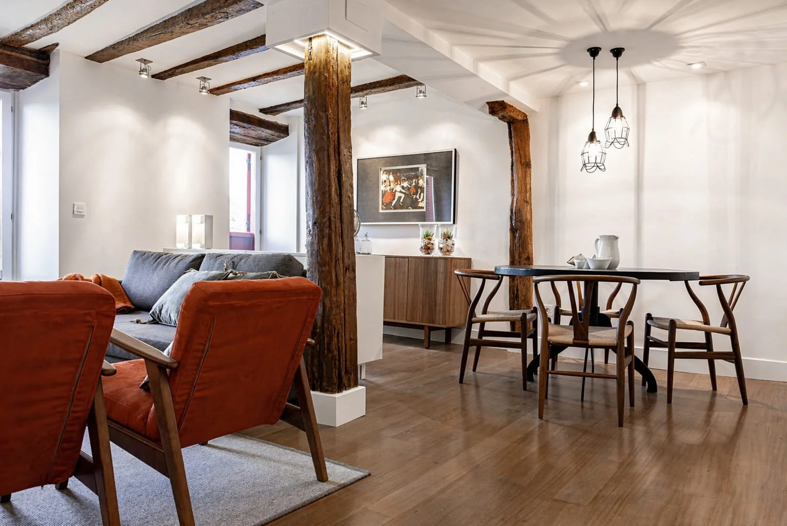 Salón comedor de estilo rústico costero en reforma integral con vigas vistas y mobiliario de madera