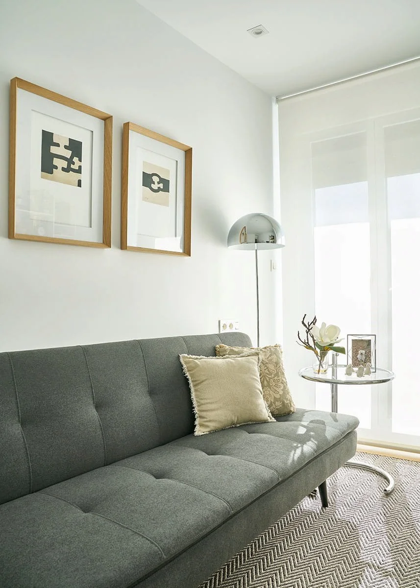 Sofá en zona de descanso de despacho con decoración y mesa auxiliar en vivienda en Urduliz Bizkaia proyecto de interiorismo y estilismo.