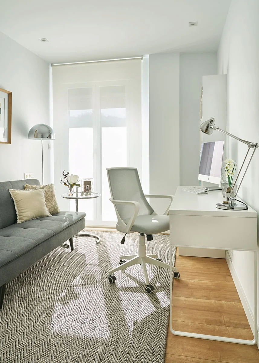 Despacho en vivienda con zona de trabajo y sofá en Urduliz Bizkaia con escritorio blanco y luz natural proyecto de interiorismo y estilismo