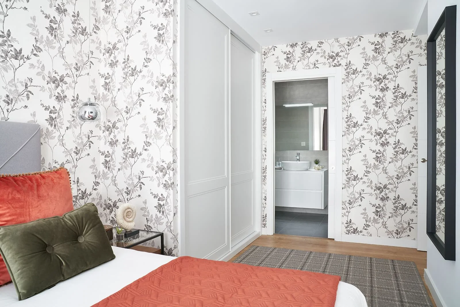 Dormitorio moderno con papel pintado y acceso a baño en suite en vivienda de Urduliz Bizkaia proyecto de interiorismo y estilismo.