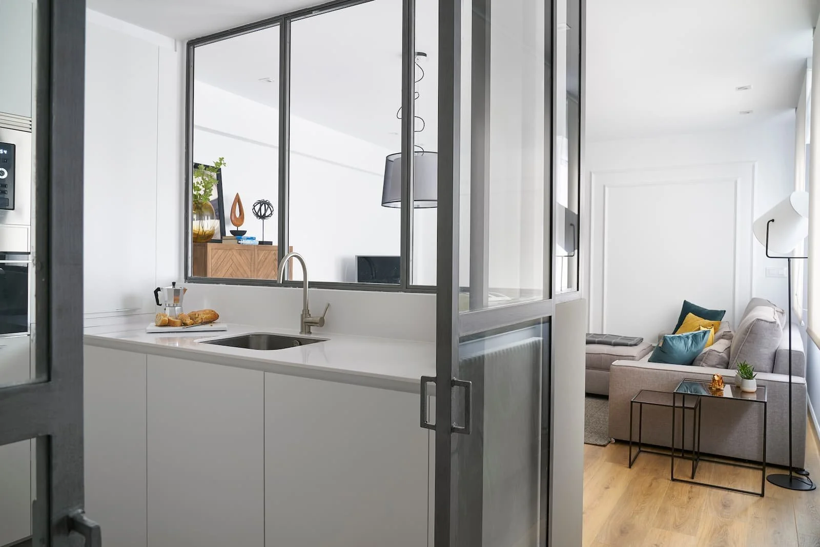 cocina abierta con cerramiento de cristal conectada al salon en reforma integral en portugalete