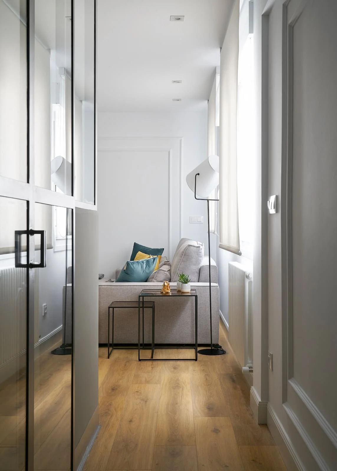 pasillo con suelo de madera que conecta con salon luminoso en reforma integral en portugalete