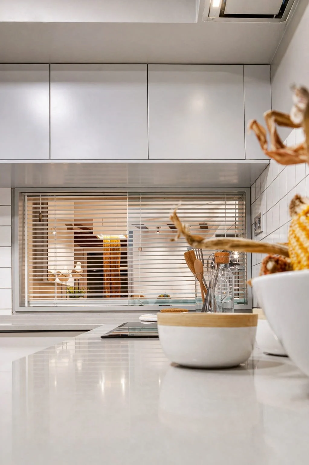 Detalle de encimera de cocina con acabados blancos y ventana interior en reforma integral en Mundaka