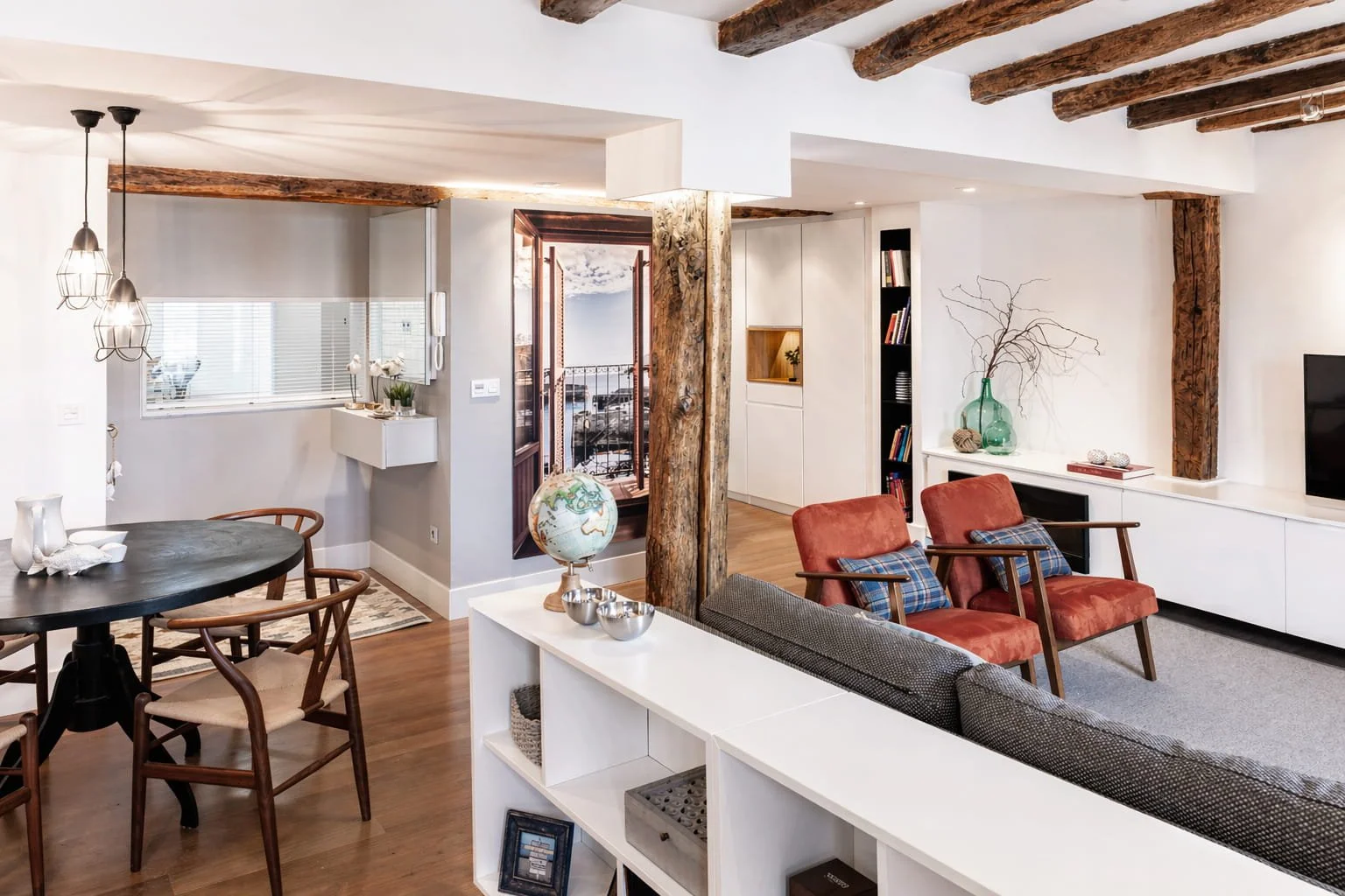 Vista general de salón y comedor en reforma integral en Mundaka con vigas de madera y distribución abierta